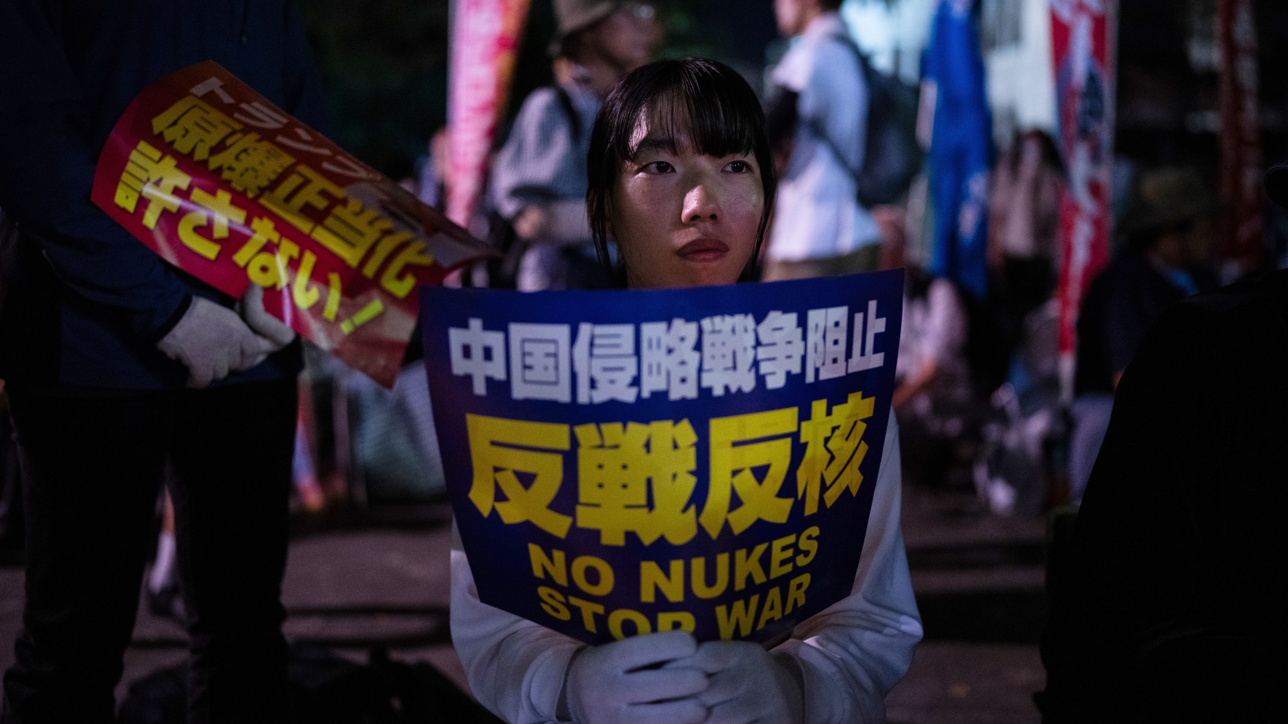 Protesters sit outside the Atomic Bomb Dome ahead of the memorial service to mark the 80th anniversary of the WWII U.S. atomic bombing in Hiroshima, Wednesday, August 6, 2025. (AP Photo/Louise Delmotte)