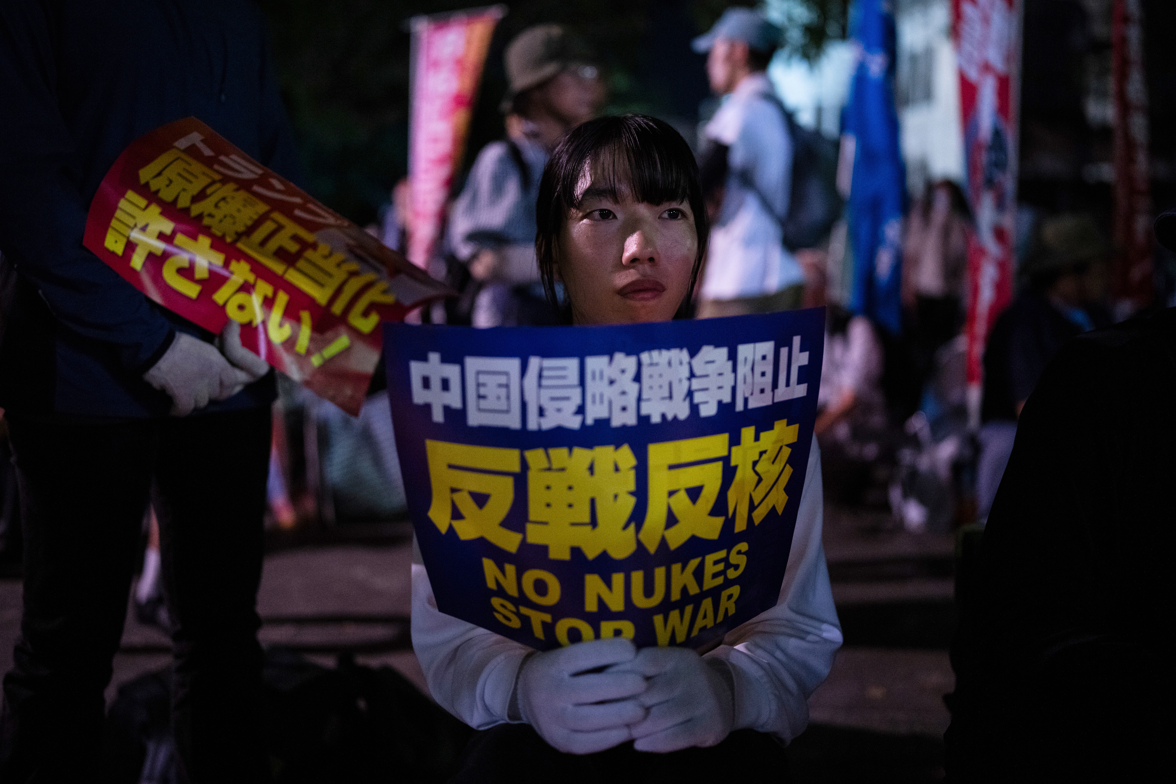 Protesters sit outside the Atomic Bomb Dome ahead of the memorial service to mark the 80th anniversary of the WWII U.S. atomic bombing in Hiroshima, Wednesday, August 6, 2025. (AP Photo/Louise Delmotte)