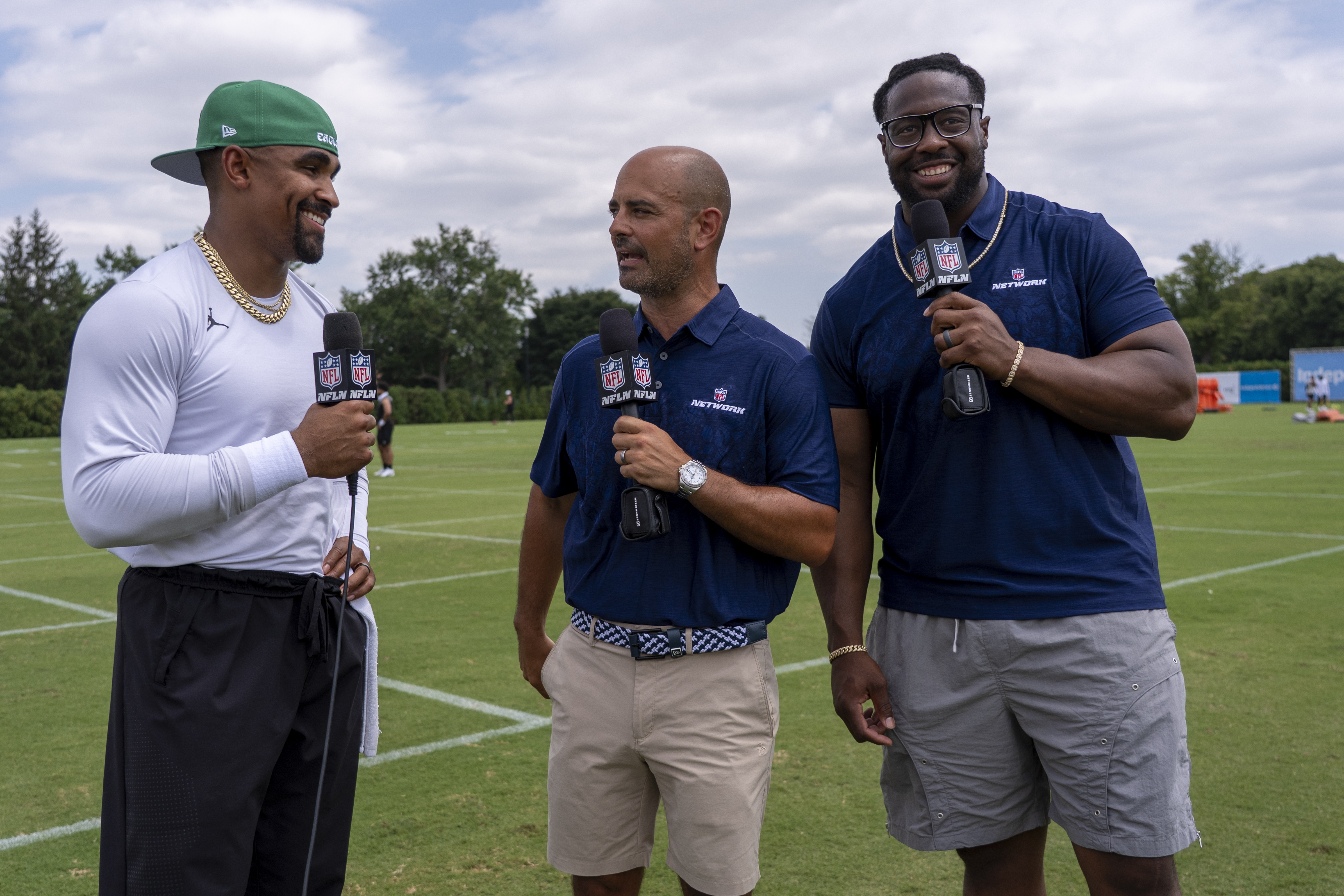 Philadelphia Eagles' Jalen Hurts, left, is interviewed by NFL Network talent Mike Garafolo, center, and Gerald McCoy, right, following practice at the team's NFL football training camp, Saturday, July 26, 2025, in Philadelphia. (AP Photo/Chris Szagola)