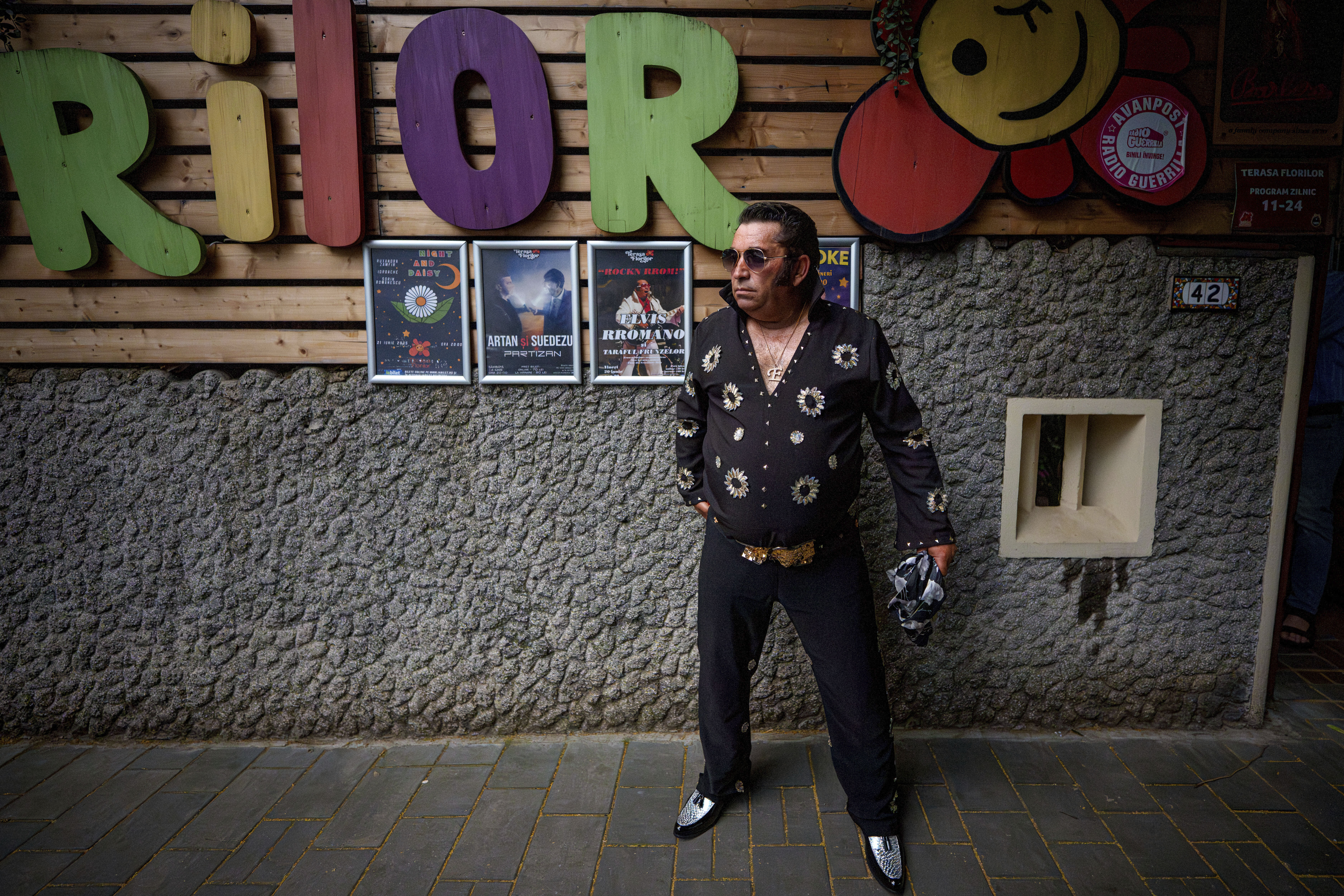 Tudor Lakatos, who goes by the stage name Elvis Rromano, poses outside the Terasa Florilor restaurant before a performance in Bucharest, Romania, Friday, June 20, 2025. (AP Photo/Andreea Alexandru)