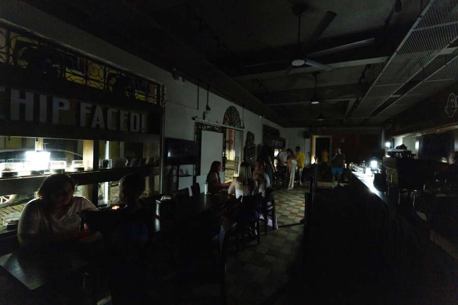 FILE - Customers sit inside a restaurant lit by battery-powered lanterns during an island-wide power outage, in Old San Juan, Puerto Rico, April 16, 2025. (AP Photo/Alejandro Granadillo, File)