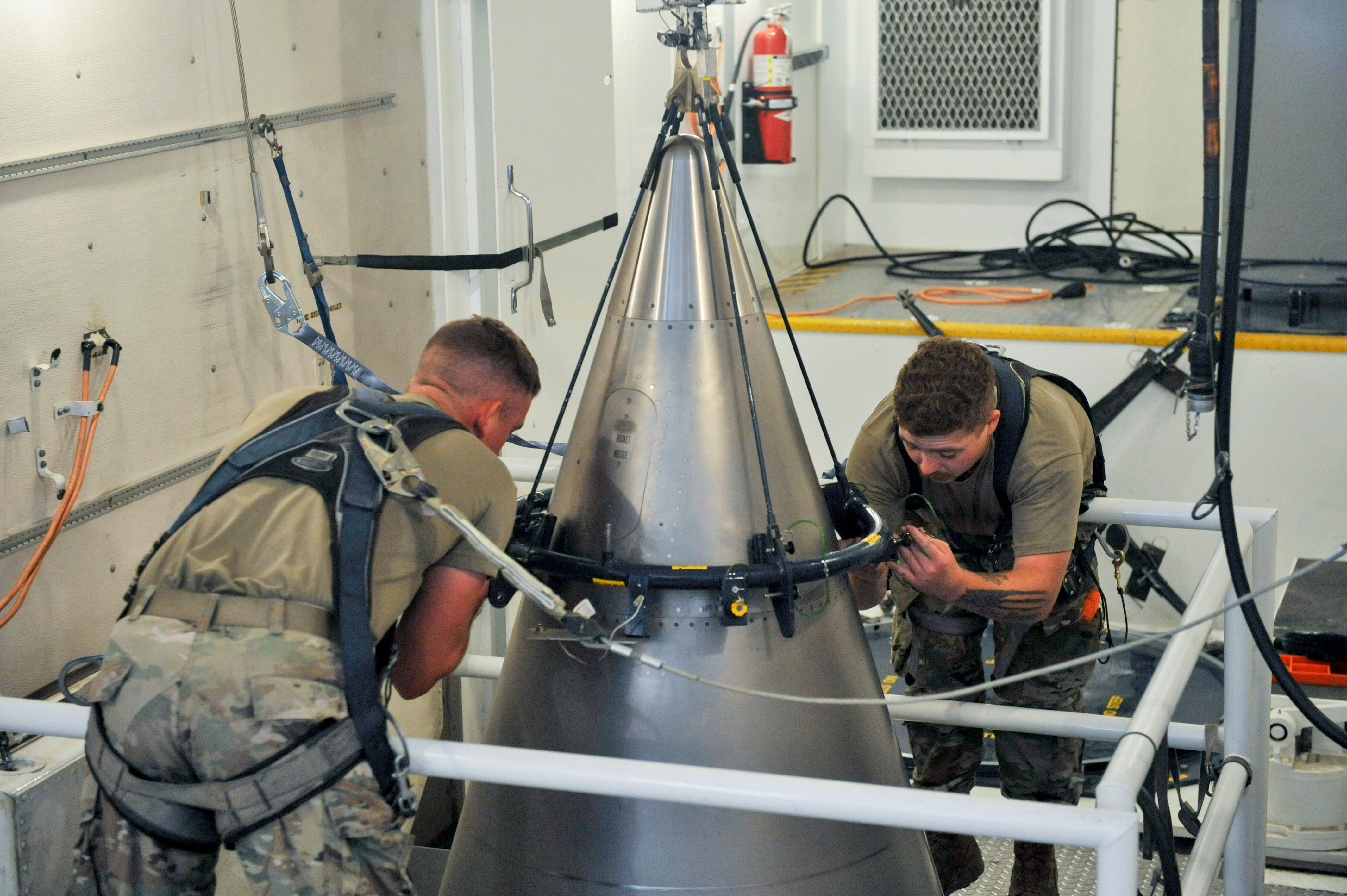 FILE - In this image provided by the U.S. Air Force, Senior Airman Jacob Deas and Airman 1st Class Jonathan Marrs secure a titanium shroud, beneath which is a nuclear warhead, at the top of a Minuteman III intercontinental ballistic missile, Aug. 24, 2023, at the Malmstrom Air Force Base in Great Falls, Mont. (John Turner/U.S. Air Force via AP, File)