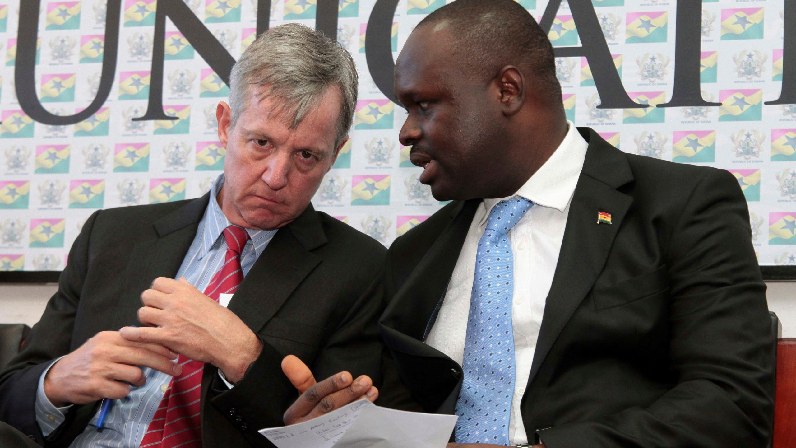 FILE - Edward Omane Boamah, Ghana's defense minister who was killed Wednesday in a helicopter crash along with several other top officials, is pictured on the right on Sept. 30, 2014 when he was information minister and talking with U.N. official Anthony Banbury at a news conference in Accra, Ghana. (AP Photo/Christian Thompson, File)