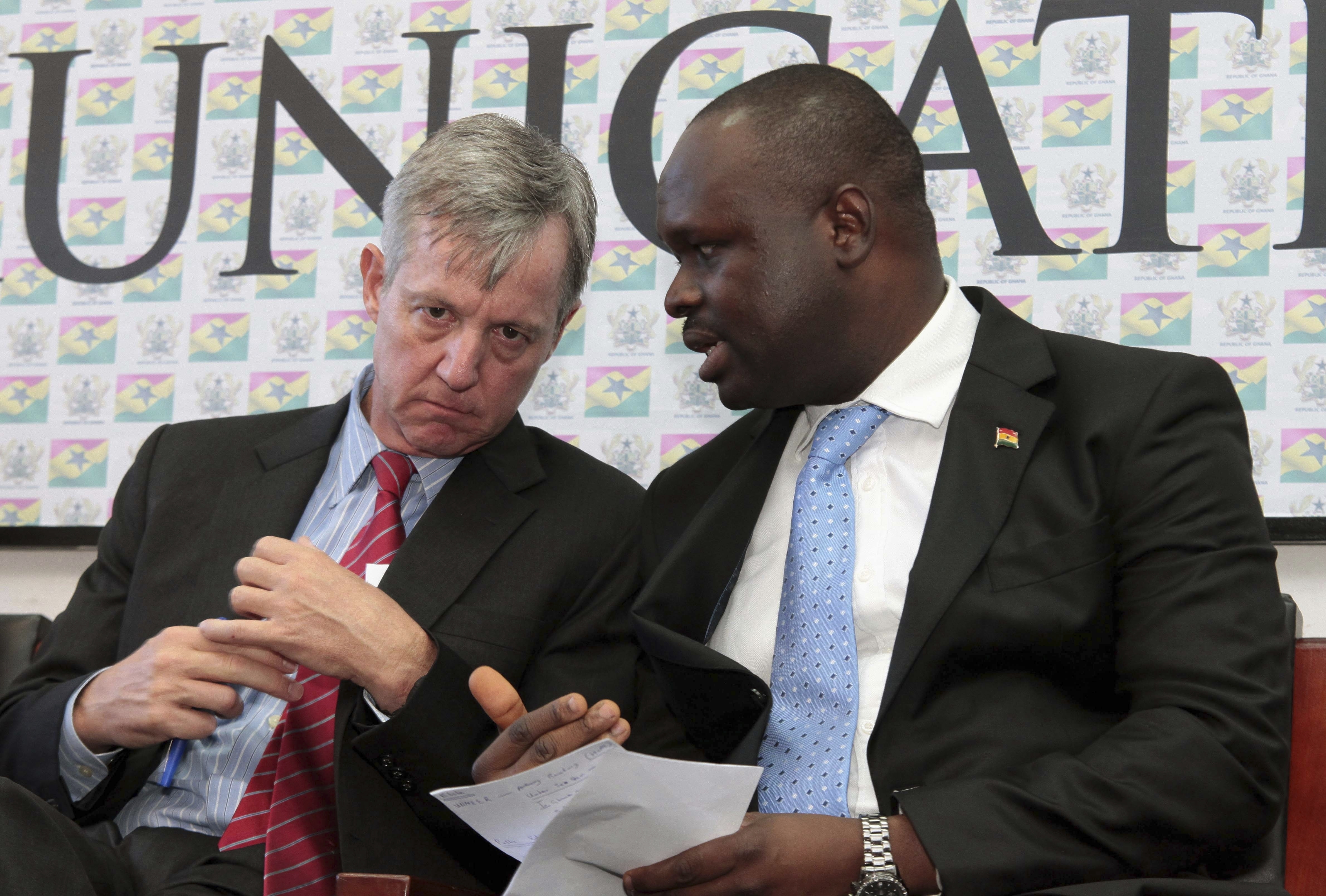 FILE - Edward Omane Boamah, Ghana's defense minister who was killed Wednesday in a helicopter crash along with several other top officials, is pictured on the right on Sept. 30, 2014 when he was information minister and talking with U.N. official Anthony Banbury at a news conference in Accra, Ghana. (AP Photo/Christian Thompson, File)
