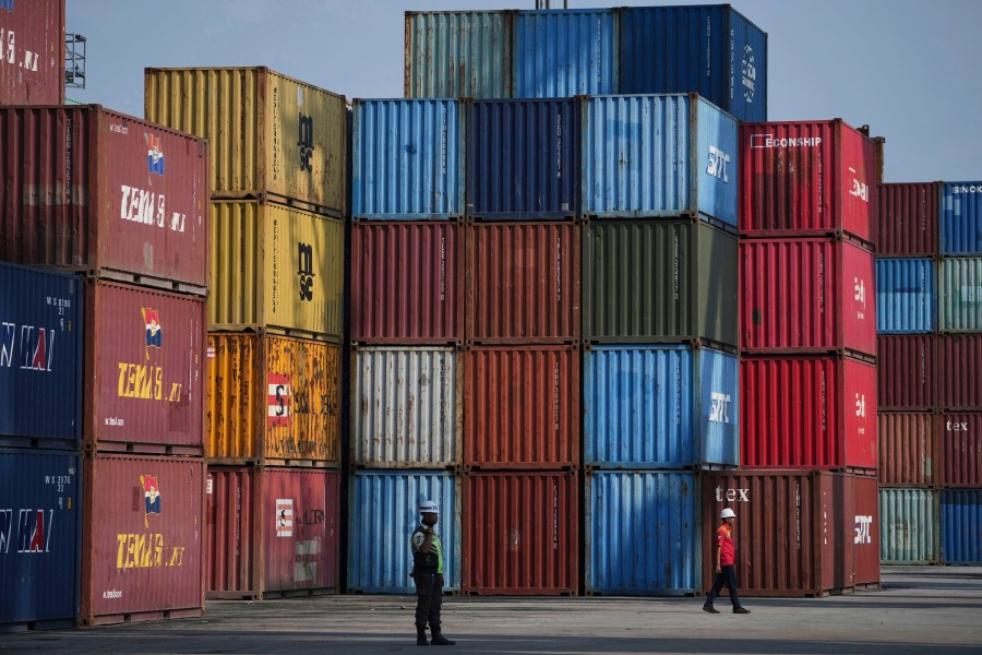 A worker walks near shipping containers at IPC Container Terminal at Tanjung Priok Port in Jakarta, Indonesia, Wednesday, Aug. 6, 2025. (AP Photo/Achmad Ibrahim)