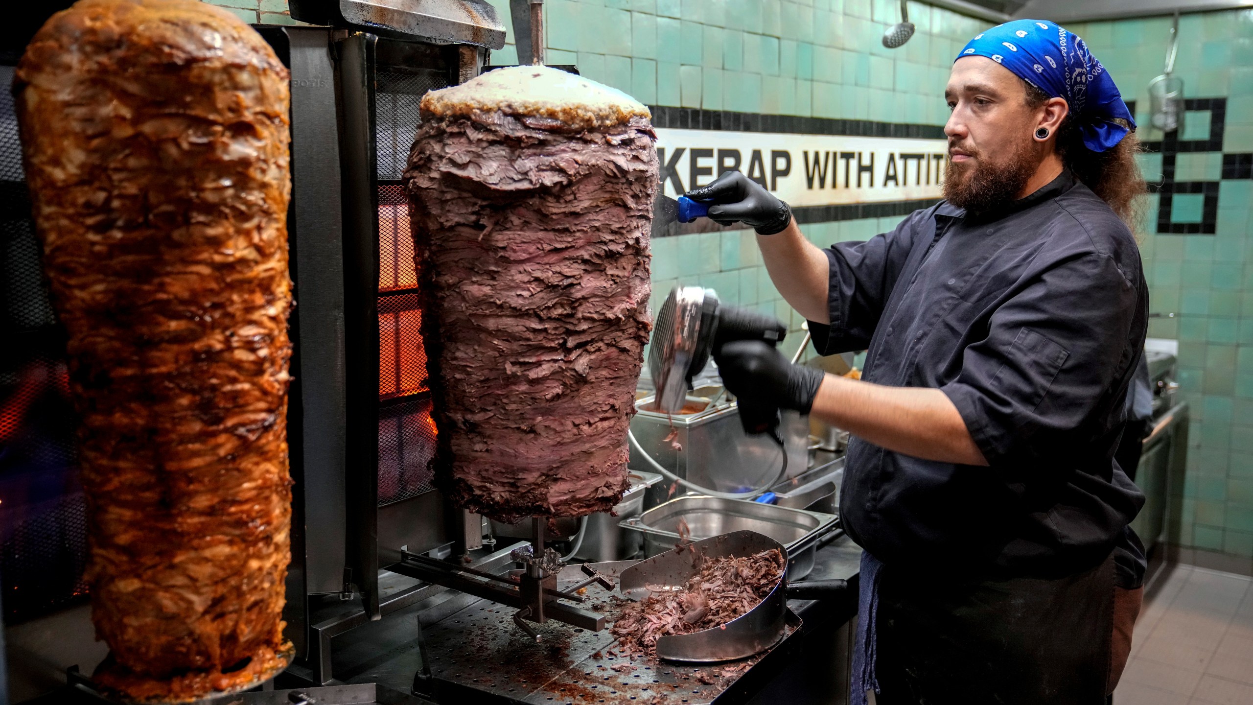FILE - Doner chef Hvesley Silva cuts doner kebab in a doner kebab restaurant in Berlin, Germany, Monday, Sept. 16, 2024. (AP Photo/Ebrahim Noroozi, File)
