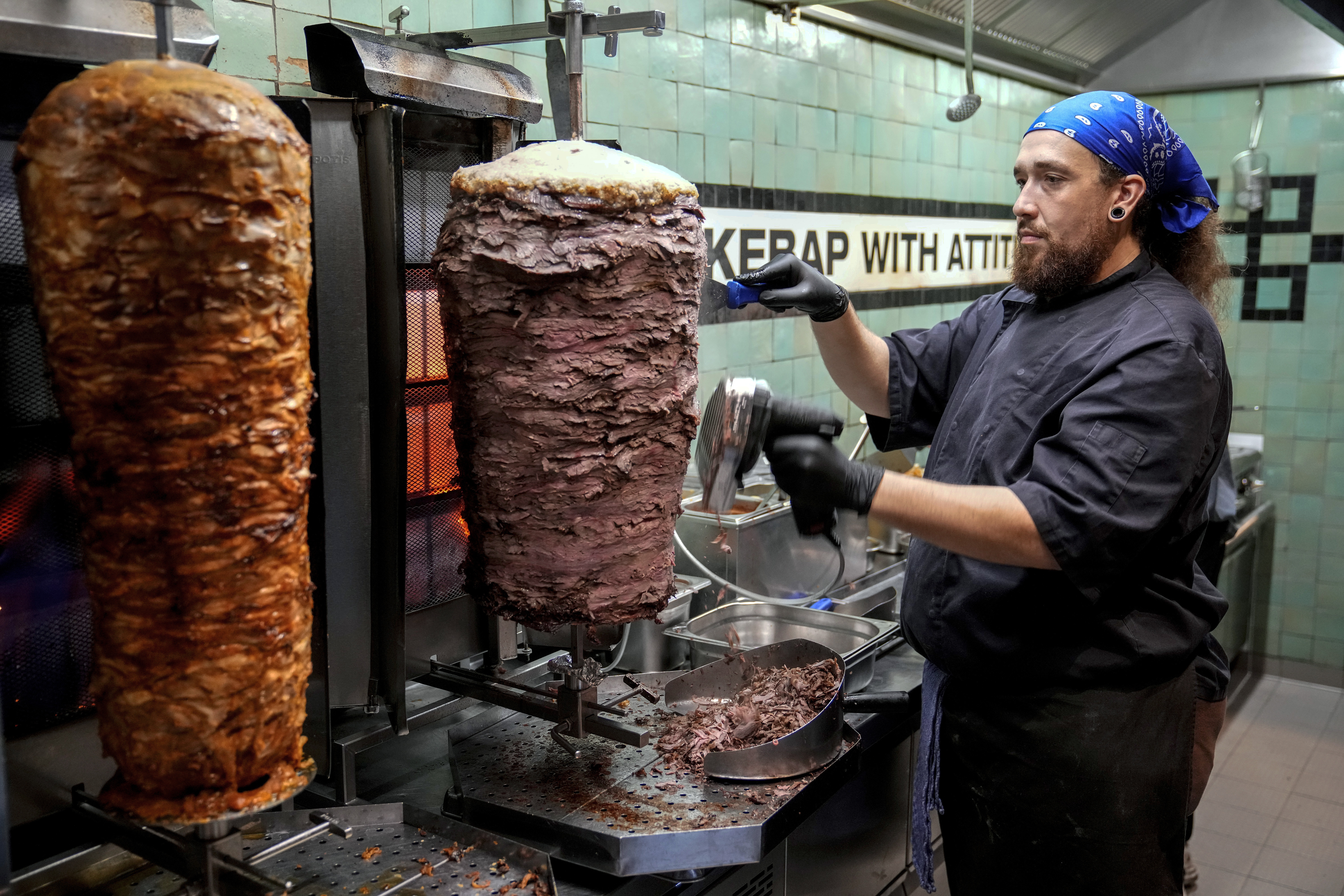 FILE - Doner chef Hvesley Silva cuts doner kebab in a doner kebab restaurant in Berlin, Germany, Monday, Sept. 16, 2024. (AP Photo/Ebrahim Noroozi, File)