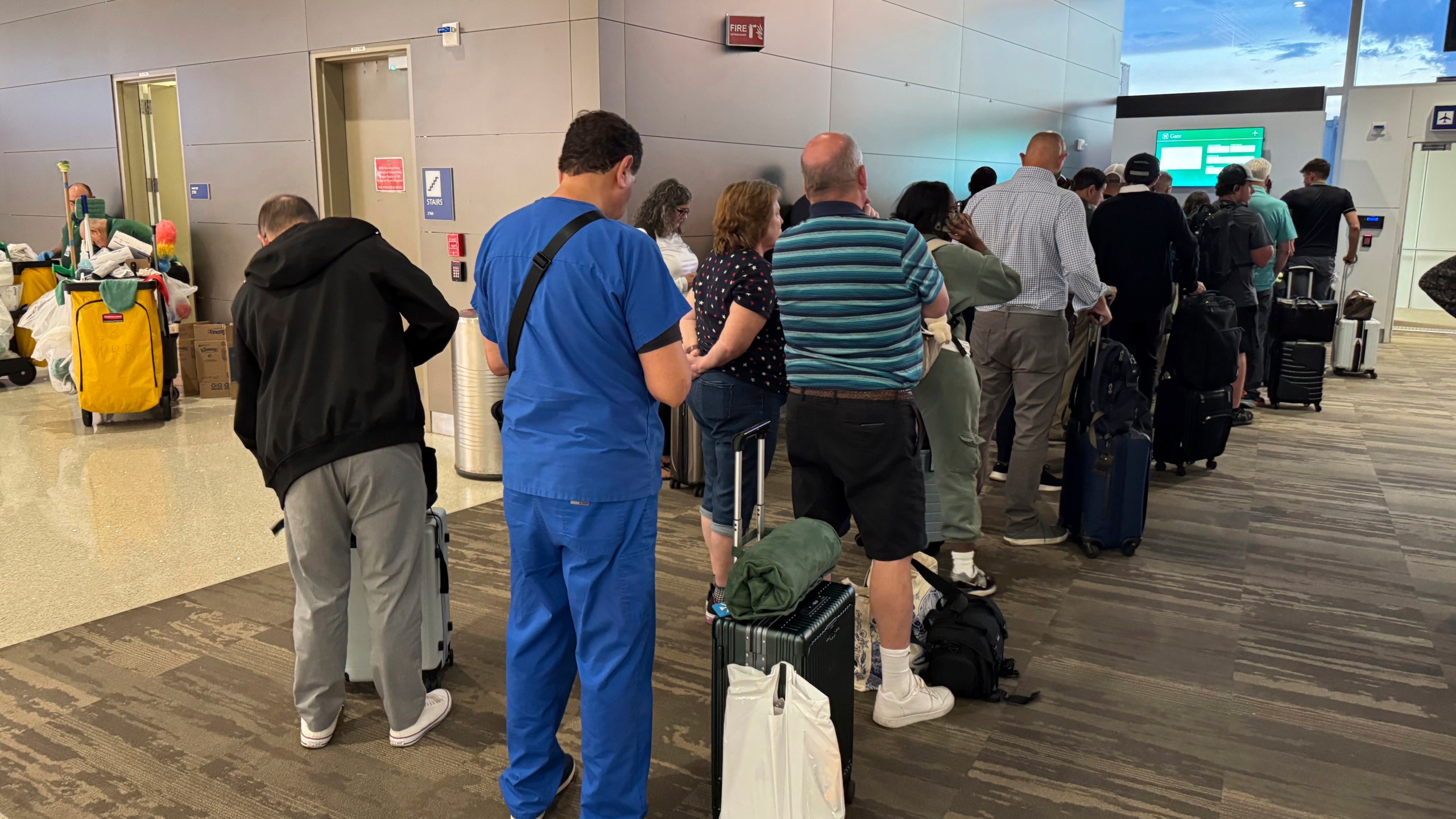 Passengers seeks updates on their delayed flight at Louis Armstrong New Orleans International Airport, Wednesday, Aug. 6, 2025, in Kenner, La. (AP Photo/Jack Brooks)