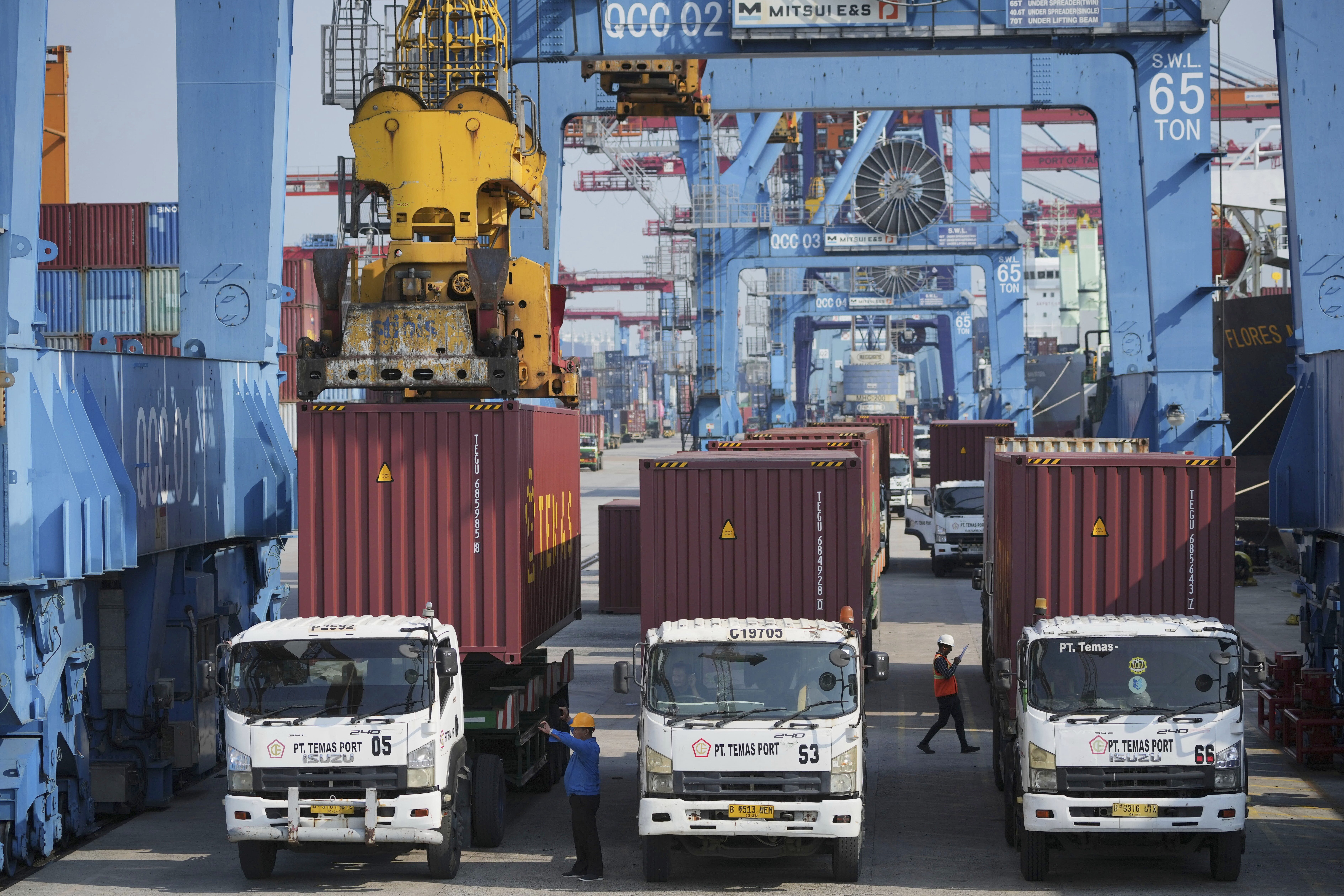 A crane unloads a shipping container from a truck at IPC Container Terminal at Tanjung Priok Port in Jakarta, Indonesia, Wednesday, Aug. 6, 2025. (AP Photo/Achmad Ibrahim)