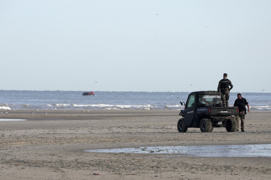 FILE - Gendarmes watch migrants on a small boat from Ecault beach, Friday July 4, 2025. (AP photo/John Leicester, File)