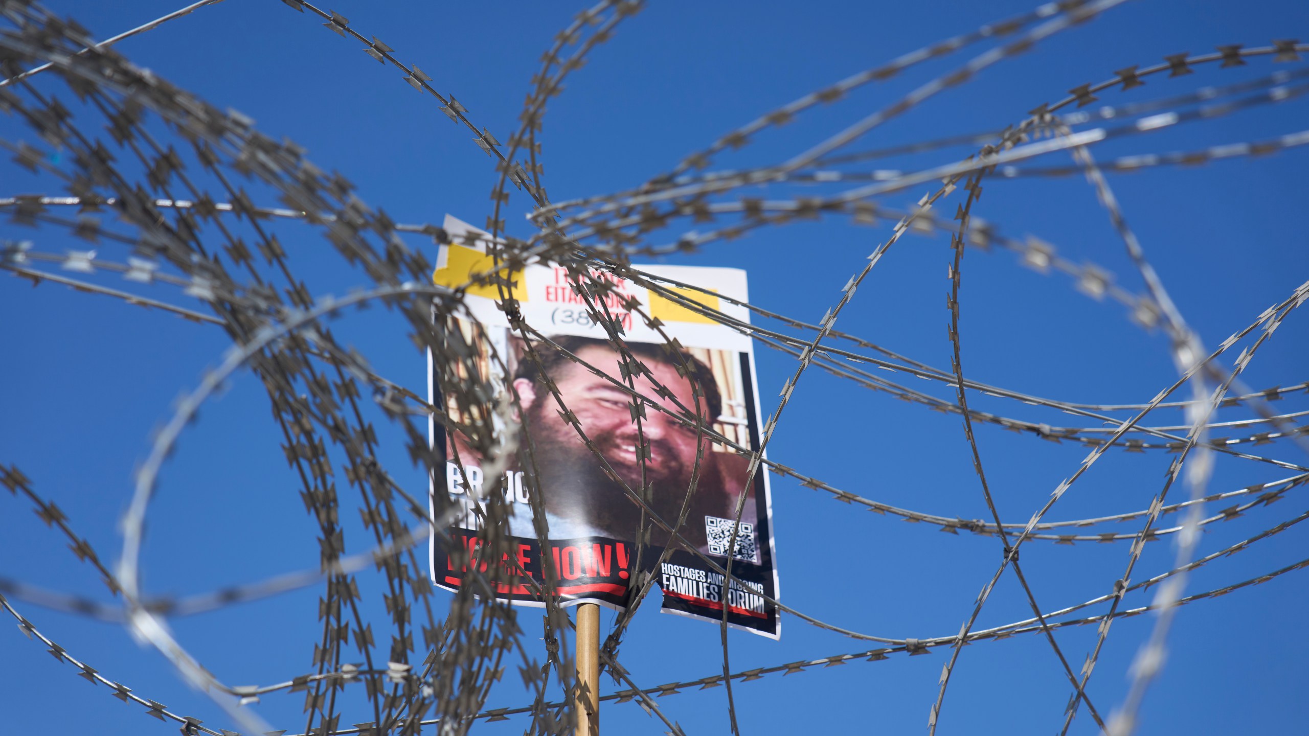 A picture of hostage Eitan Horn, held in Hamas captive in the Gaza Strip, hangs on a barbed wire during a protest by families at the plaza known as the hostages square in Tel Aviv, Israel, Saturday, Aug. 2, 2025. ( AP Photo/Ariel Schalit)