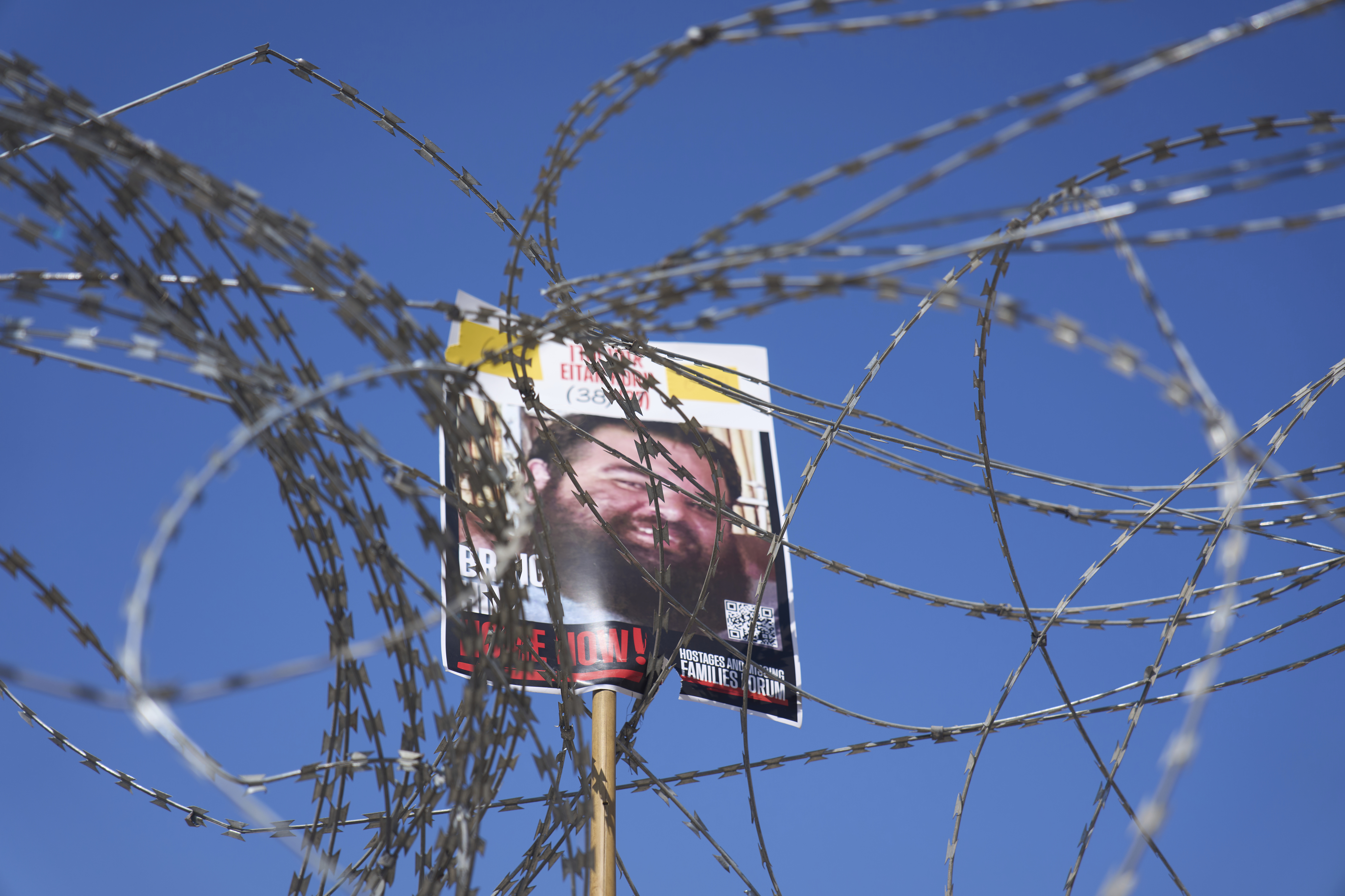 A picture of hostage Eitan Horn, held in Hamas captive in the Gaza Strip, hangs on a barbed wire during a protest by families at the plaza known as the hostages square in Tel Aviv, Israel, Saturday, Aug. 2, 2025. ( AP Photo/Ariel Schalit)