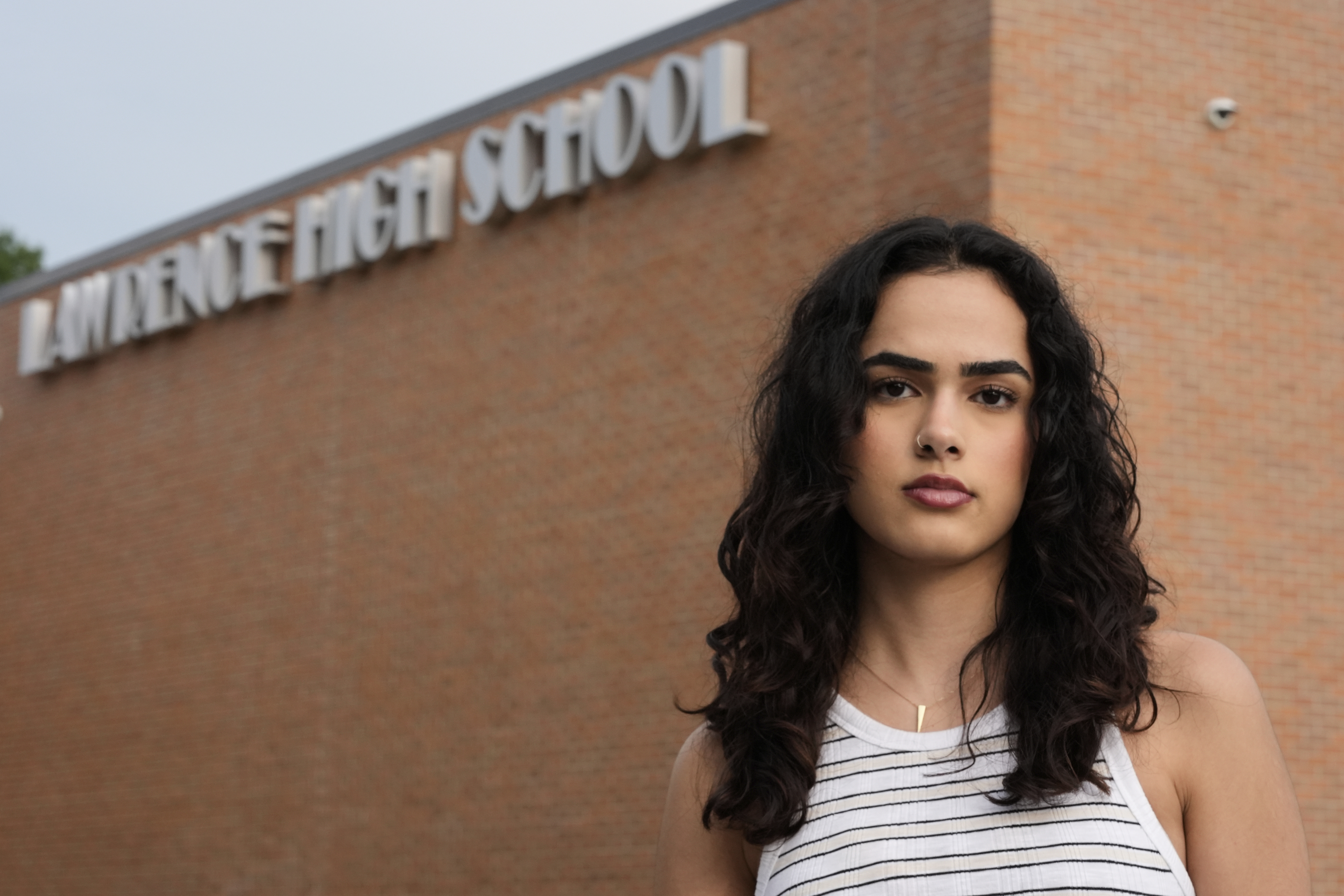 Natasha Torkzaban stands outside Lawrence High School, where she and other students have filed a lawsuit against the school district's use of digital surveillance software, Sunday, Aug. 3, 2025, in Lawrence, Kan. (AP Photo/Charlie Riedel)