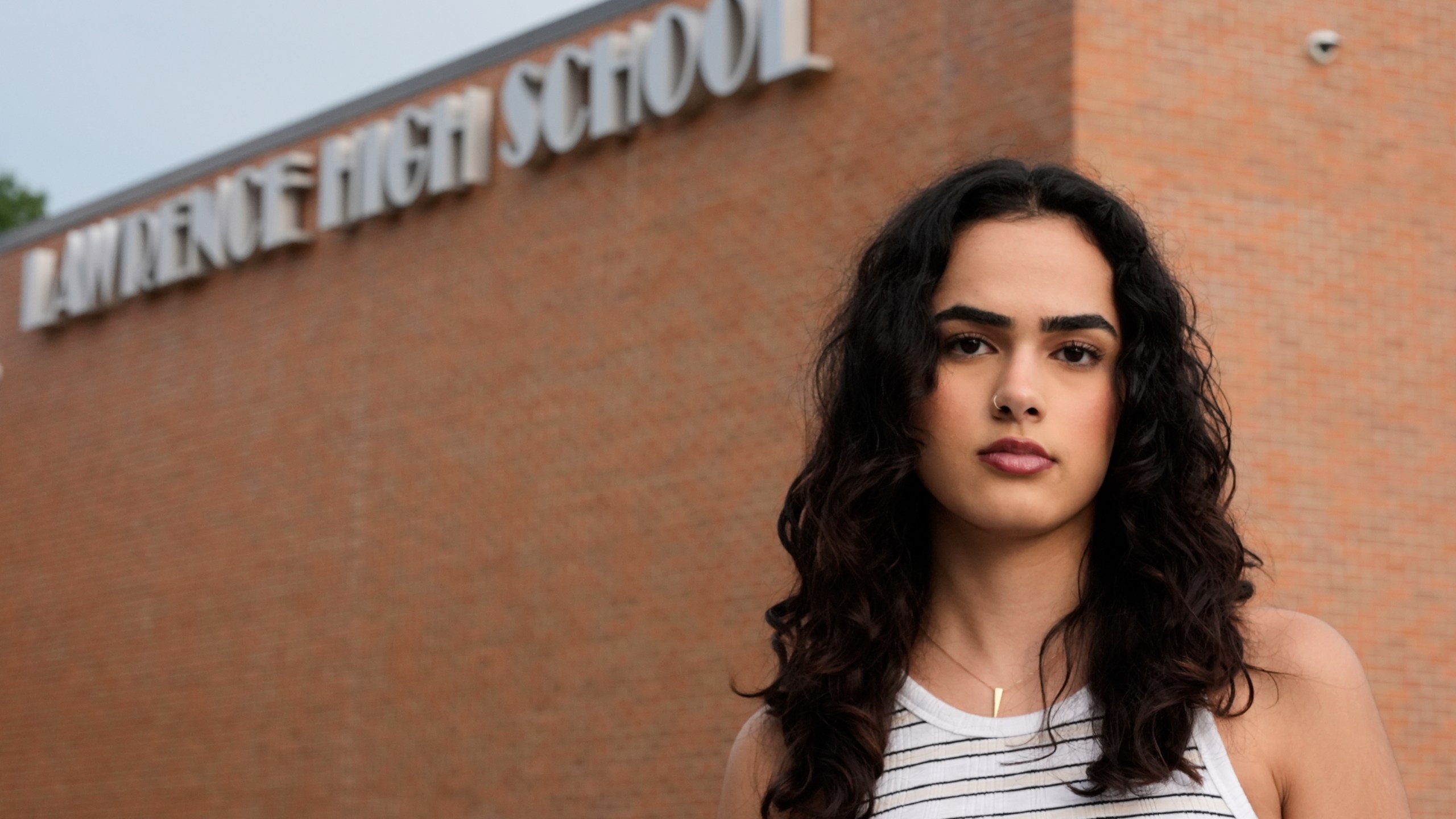 Natasha Torkzaban stands outside Lawrence High School, where she and other students have filed a lawsuit against the school district's use of digital surveillance software, Sunday, Aug. 3, 2025, in Lawrence, Kan. (AP Photo/Charlie Riedel)