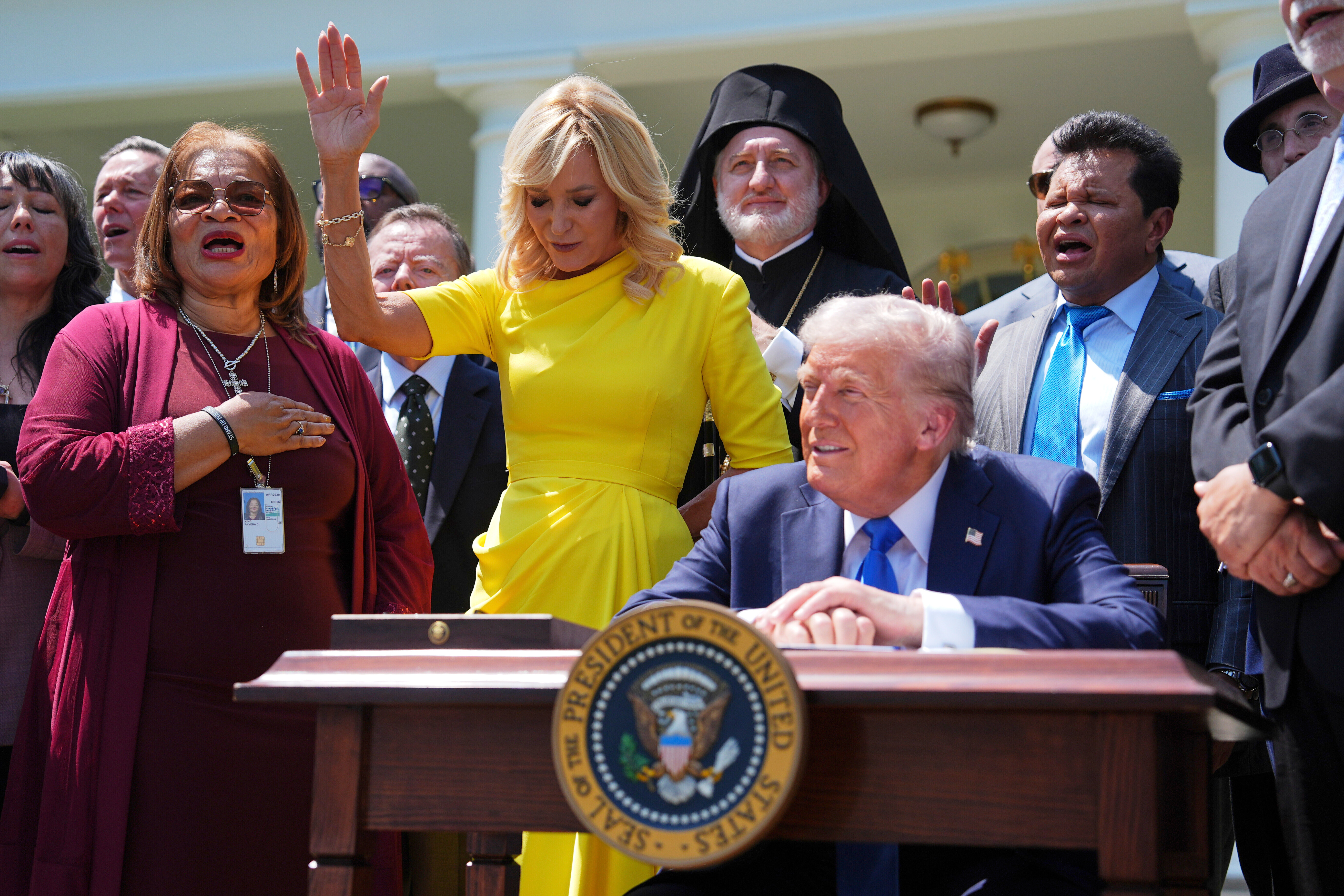 FILE - President Donald Trump sits at a desk as he and religious leaders listen to a musical performance before Trump signs an executive order during a National Day of Prayer event in the Rose Garden of the White House, May 1, 2025, in Washington. (AP Photo/Evan Vucci, File)