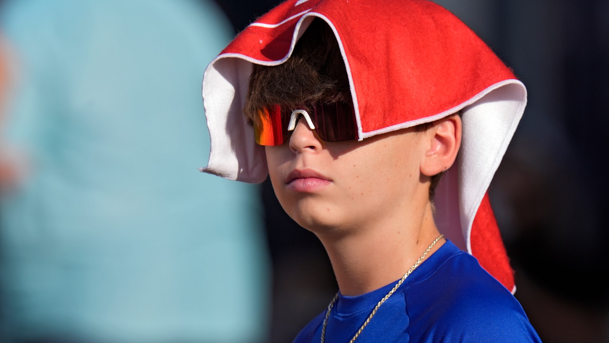 FILE - A young Tampa Bay Buccaneers fan covers his head to avoid the sun and heat during Back Together Weekend at an NFL football training camp practice Sunday, July 27, 2025, in Tampa, Fla. (AP Photo/Chris O'Meara, File)
