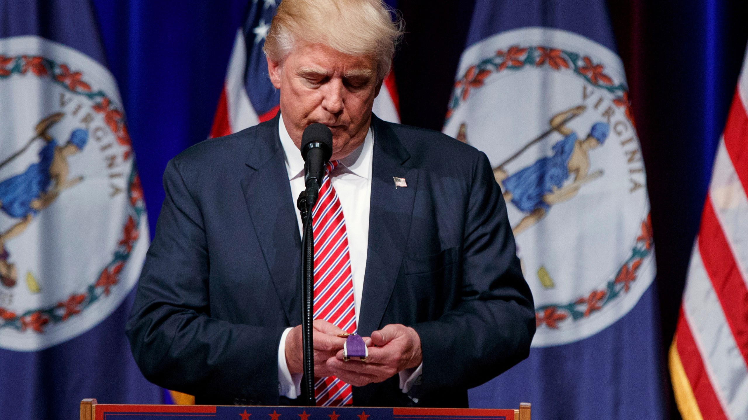 FILE - Republican presidential candidate Donald Trump holds a Purple Heart medal given to him by a supporter during a campaign rally, Aug. 2, 2016, in Ashburn, Va. (AP Photo/Evan Vucci, File)