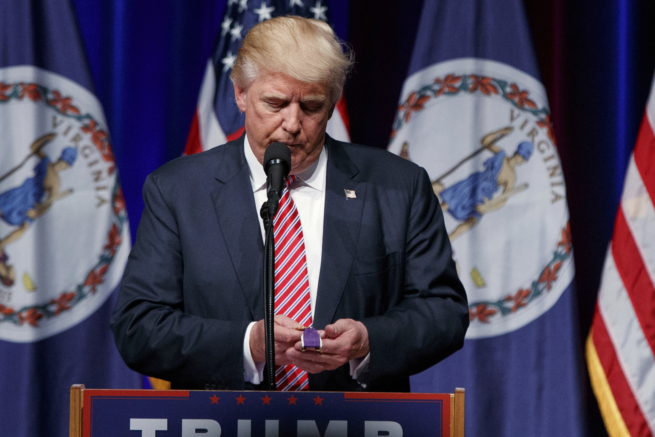 FILE - Republican presidential candidate Donald Trump holds a Purple Heart medal given to him by a supporter during a campaign rally, Aug. 2, 2016, in Ashburn, Va. (AP Photo/Evan Vucci, File)