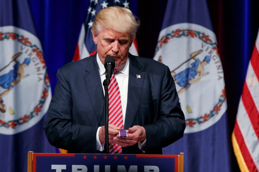 FILE - Republican presidential candidate Donald Trump holds a Purple Heart medal given to him by a supporter during a campaign rally, Aug. 2, 2016, in Ashburn, Va. (AP Photo/Evan Vucci, File)