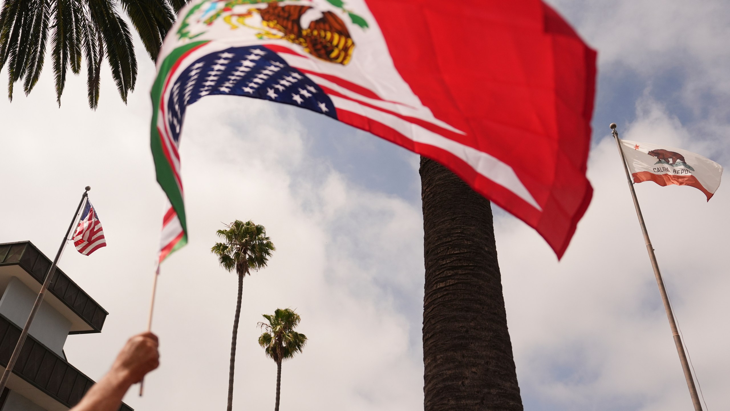 A demonstrator waves a flag during a protest in reaction to recent immigration raids on Friday, July 11, 2025, in Oxnard, Calif. (AP Photo/Jae C. Hong)
