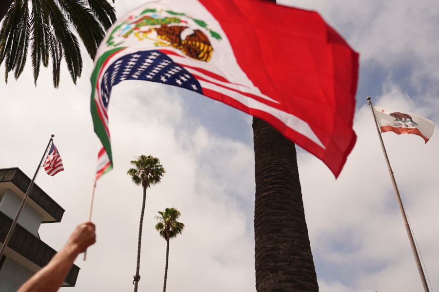 A demonstrator waves a flag during a protest in reaction to recent immigration raids on Friday, July 11, 2025, in Oxnard, Calif. (AP Photo/Jae C. Hong)