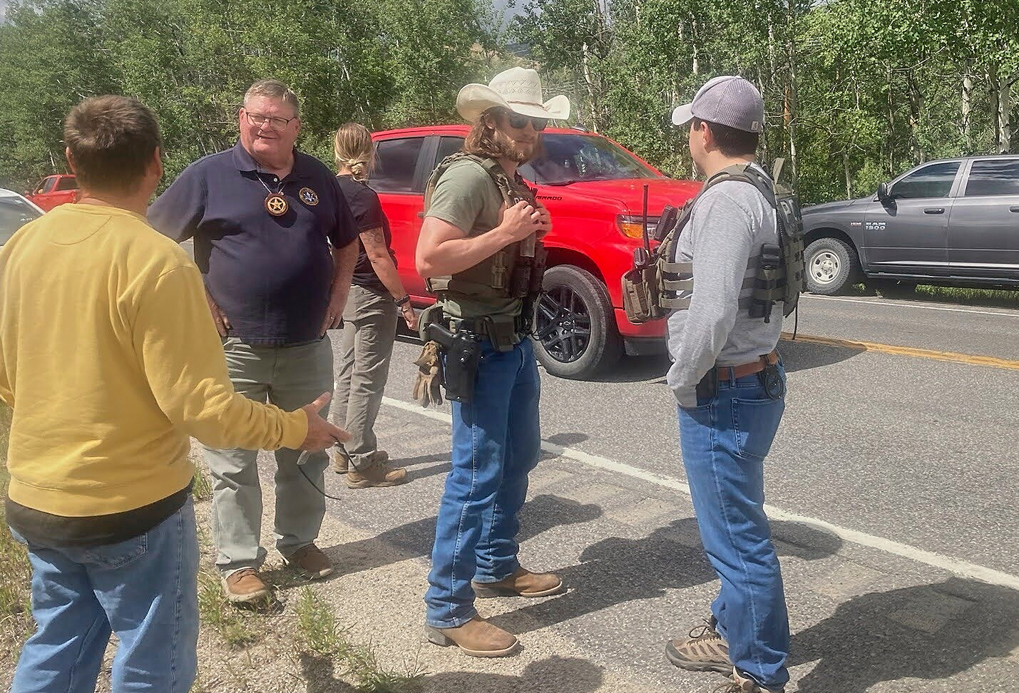 Law enforcement officers stand at the scene where Michael Brown, a suspect in a shooting at a Montana bar that left four people dead, was apprehended on Friday, Aug. 8, 2025, outside of Anaconda, Mont. (Duncan Adams/The Montana Standard via AP)
