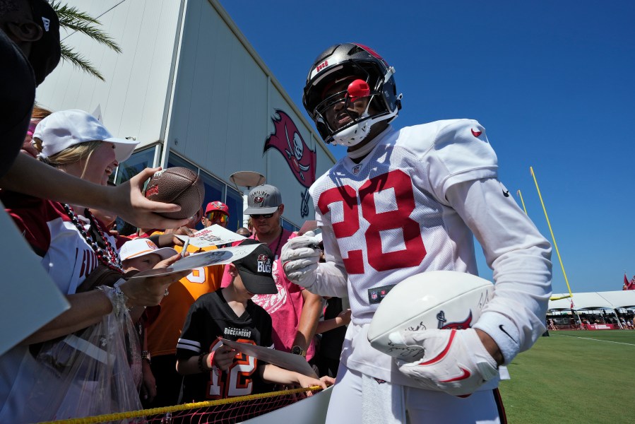 Tampa Bay Buccaneers safety Shilo Sanders signs autographs for fans during Back Together Weekend at an NFL football training camp practice Sunday, July 27, 2025, in Tampa, Fla. (AP Photo/Chris O'Meara)
