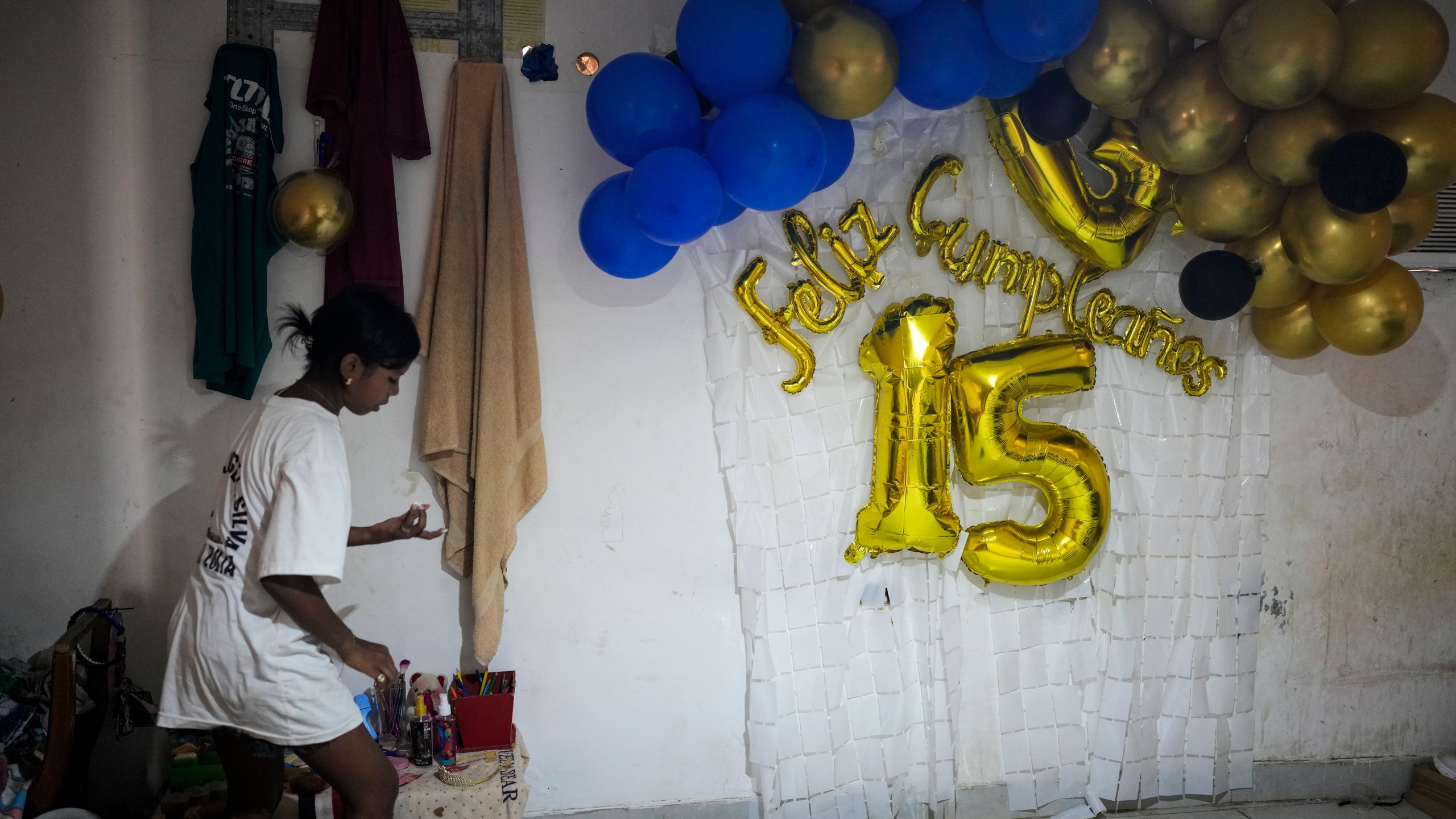Yaribel Romero, one of five children who returned to Venezuela from Mexico with their parents after abandoning plans to reach the United States amid President Donald Trump's migration crackdown, tidies her room the day after her fifteenth birthday, in Maracaibo, Venezuela, Monday, June 16, 2025. (AP Photo/Matias Delacroix)