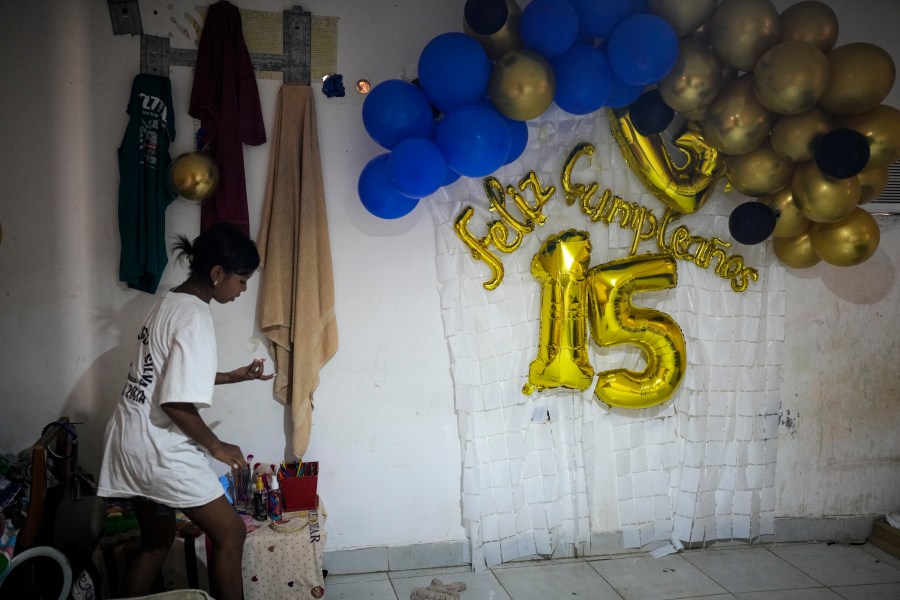 Yaribel Romero, one of five children who returned to Venezuela from Mexico with their parents after abandoning plans to reach the United States amid President Donald Trump's migration crackdown, tidies her room the day after her fifteenth birthday, in Maracaibo, Venezuela, Monday, June 16, 2025. (AP Photo/Matias Delacroix)