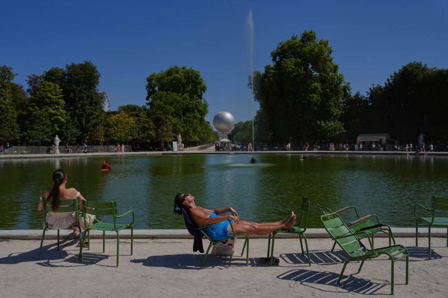 A man sunbaths in the Tuileries gardens, Monday, Aug. 11, 2025 in Paris. (AP Photo/Aurelien Morissard)