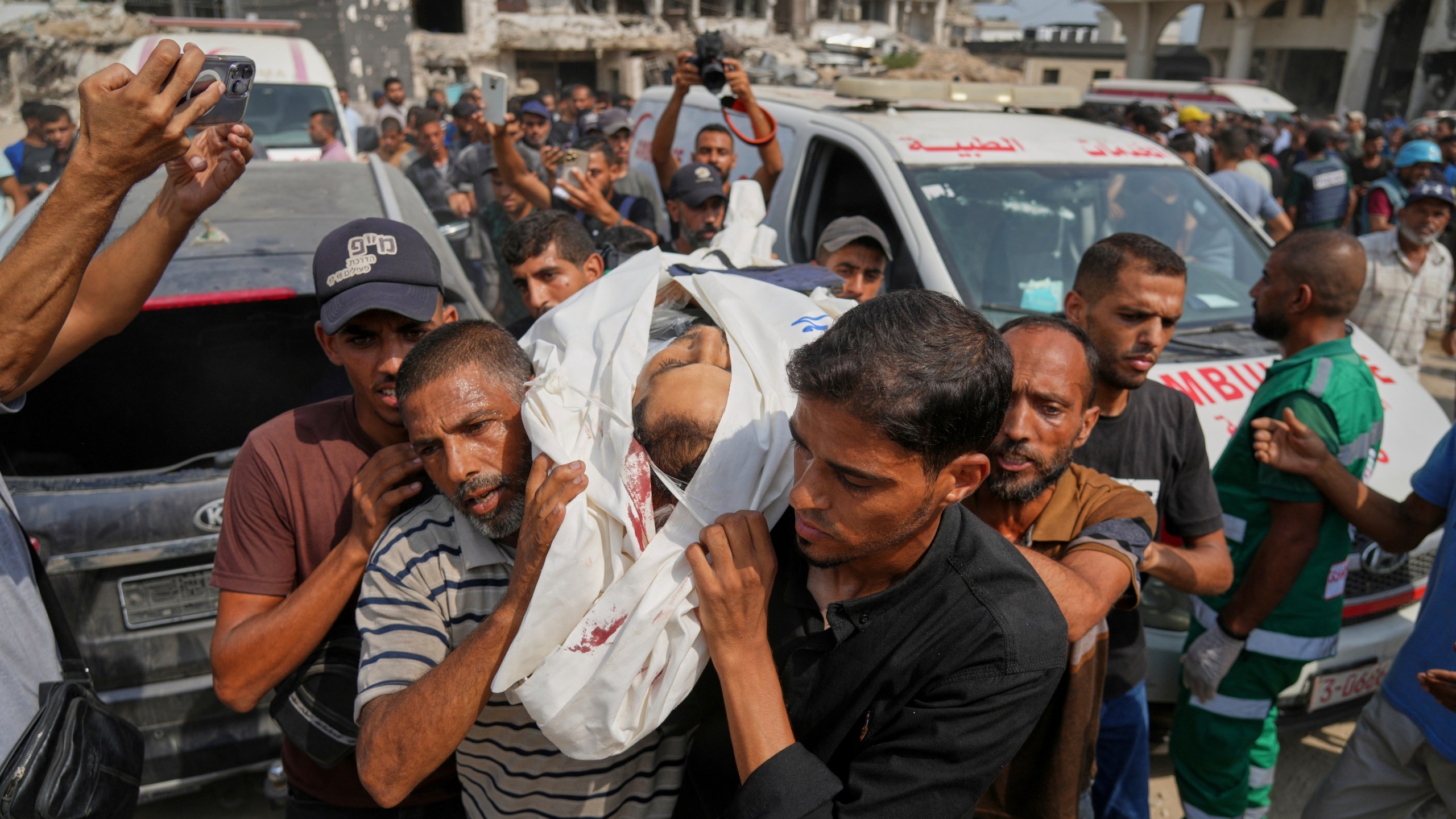 Palestinians carry the body of Al Jazeera journalist Mohamed Qreiqeh, one of five Al Jazeera staff members killed in a targeted Israeli drone strike, during his funeral outside Gaza City's Shifa Hospital complex on Monday, Aug. 11, 2025. (AP Photo/Jehad Alshrafi)