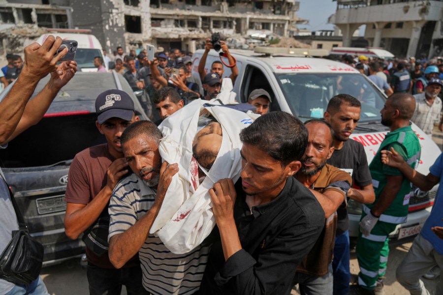 Palestinians carry the body of Al Jazeera journalist Mohamed Qreiqeh, one of five Al Jazeera staff members killed in a targeted Israeli drone strike, during his funeral outside Gaza City's Shifa Hospital complex on Monday, Aug. 11, 2025. (AP Photo/Jehad Alshrafi)