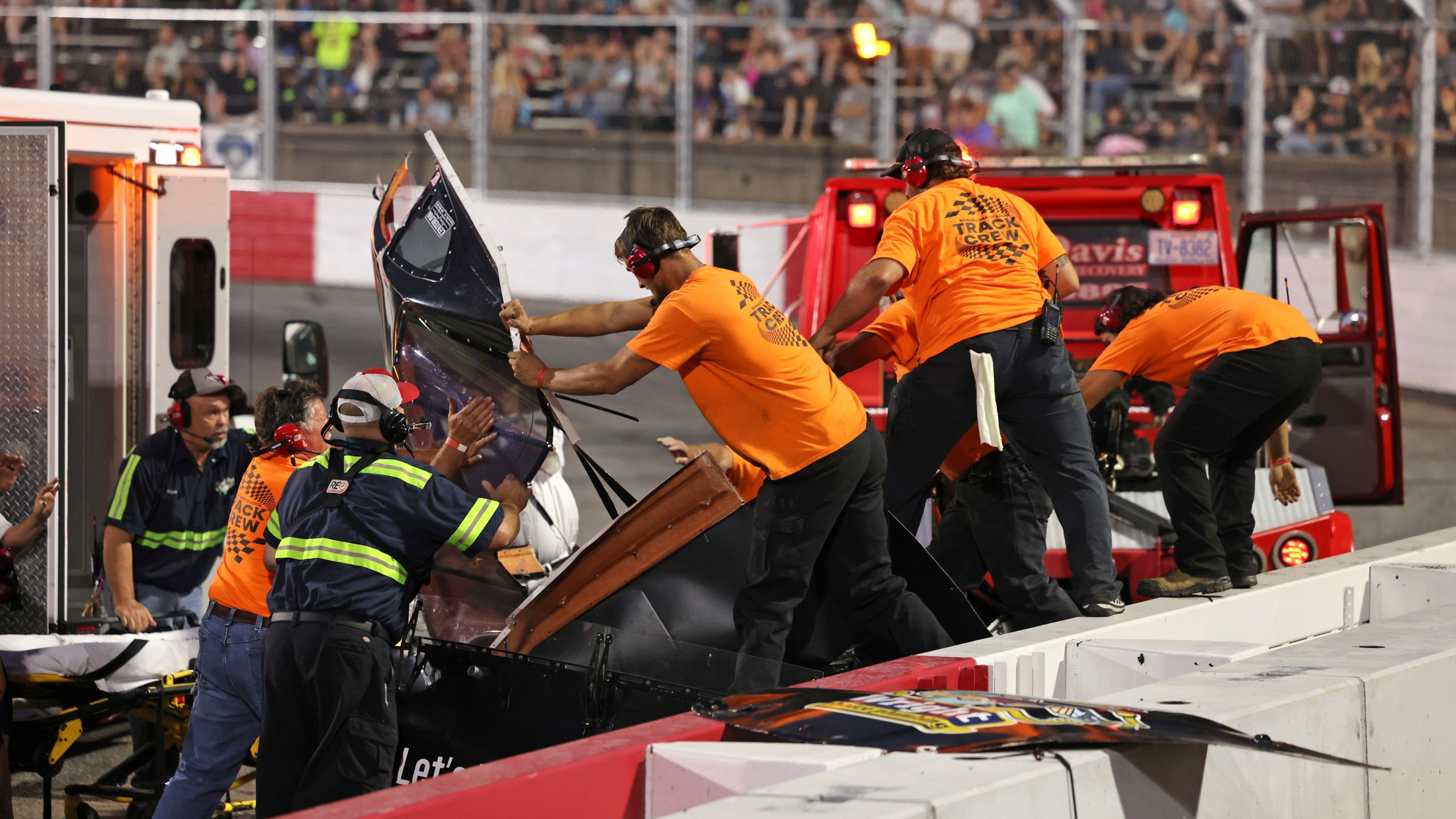 Track crew members rip the roof off of Robbie Brewer's car to remove him after a medical emergency in the first 20-lap Sportsman Series race at Bowman Gray Stadium, Saturday, Aug. 9, 2025, in Winston-Salem, N.C. (Walt Unks/The Winston-Salem Journal via AP)