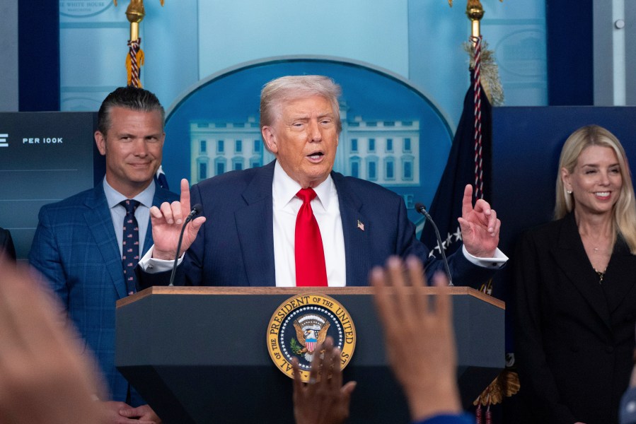 FILE - President Donald Trump speaks with reporters in the James Brady Press Briefing Room at the White House, Aug. 11, 2025, in Washington, as Secretary of Defense Pete Hegseth, left, and Attorney General Pam Bondi look on. (AP Photo/Alex Brandon, File)