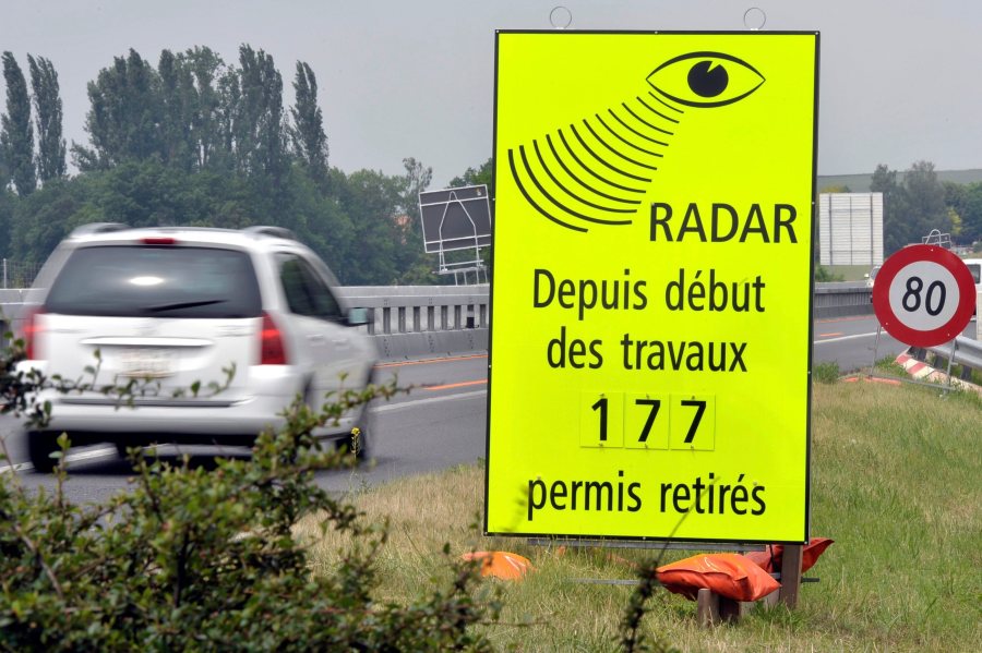 FILE - A vehicle passes in front of a sign of the Vaud Cantonal Police indicating the number of driving licences withdrawn for speeding in the construction zone on the A1 motorway between Lausanne and Yverdon, Switzerland, Tuesday, June 15, 2010. (Dominic Favre/Keystone via AP, file)