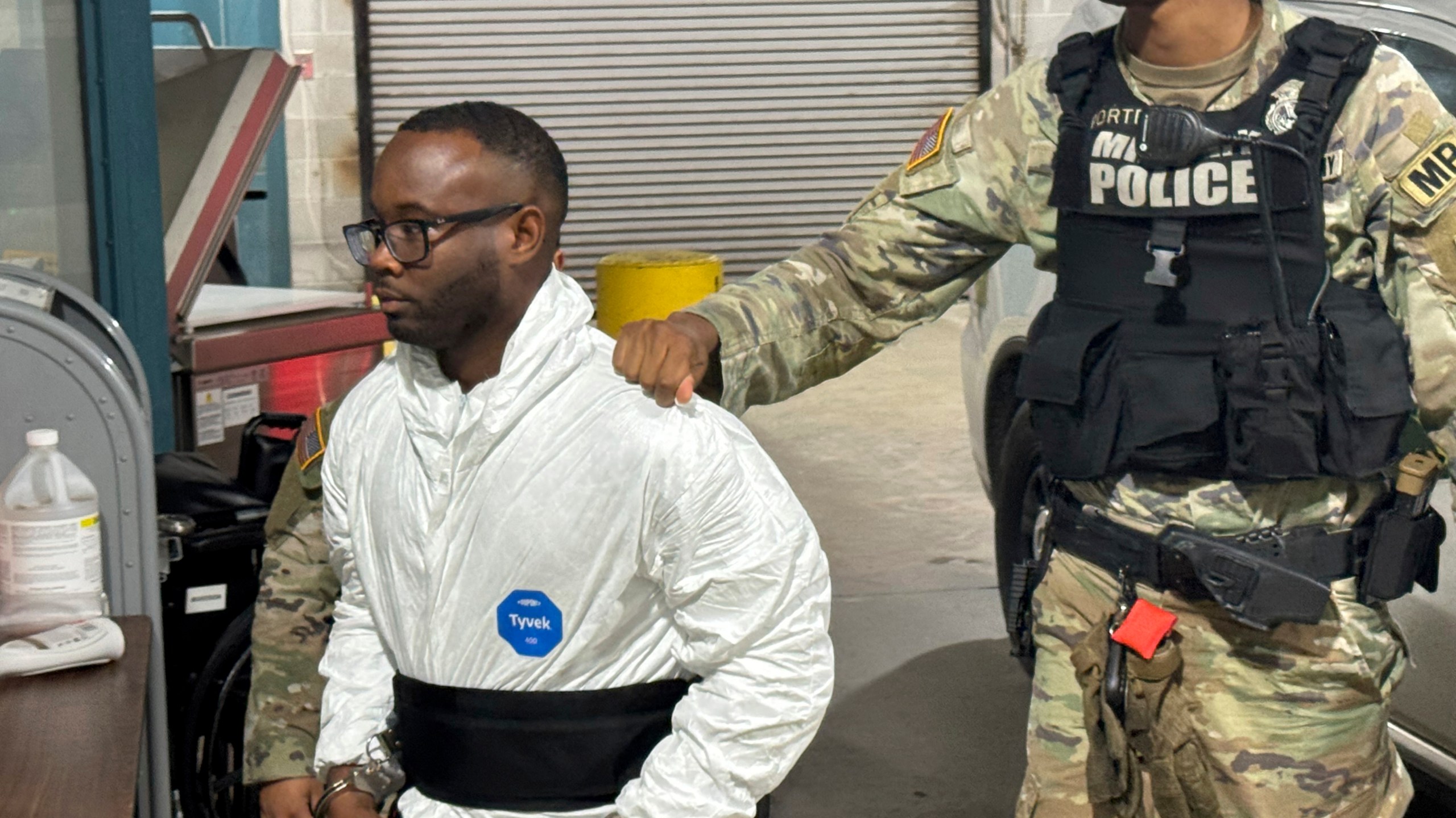 Sgt. Quornelius Radford, a suspect in the shooting of five soldiers at Fort Stewart, is escorted by military police into a booking room at the Liberty County Jail in Hinesville, Ga., Wednesday, Aug. 6, 2025. (AP Photo/Lewis M. Levine)