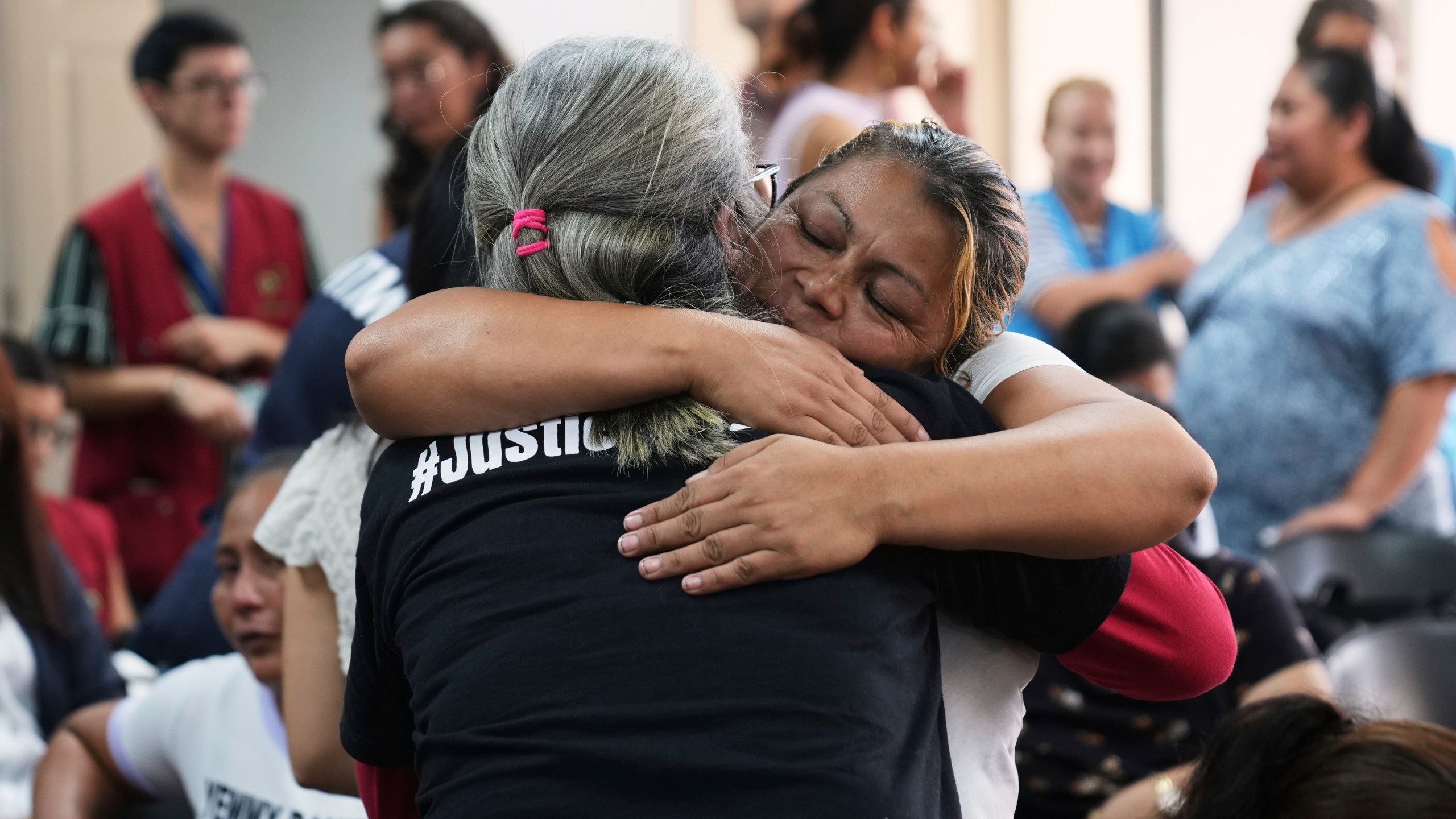 Relatives of the 41 girls killed in a fire at a government-run facility for at-risk girls in 2017, embrace in a courtroom during a hearing for seven people accused of responsibility, in Guatemala City, Tuesday, Aug. 12, 2025. (AP Photo/Moises Castillo)