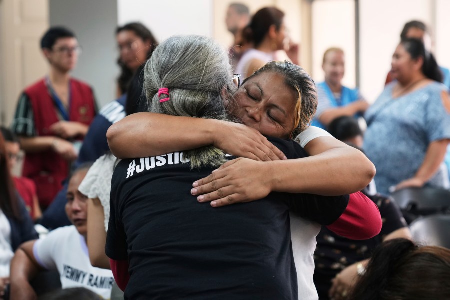 Relatives of the 41 girls killed in a fire at a government-run facility for at-risk girls in 2017, embrace in a courtroom during a hearing for seven people accused of responsibility, in Guatemala City, Tuesday, Aug. 12, 2025. (AP Photo/Moises Castillo)