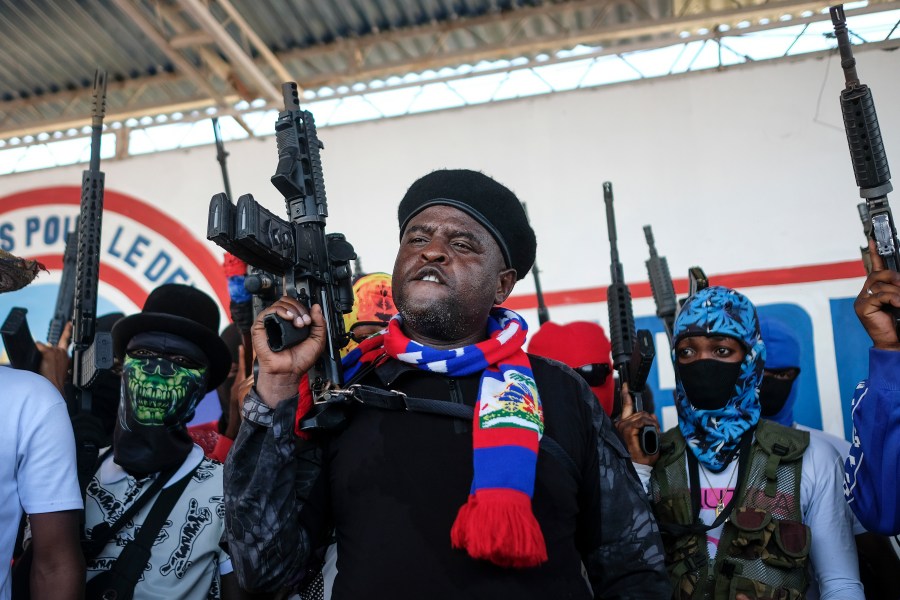 FILE - Leader of the "G9 and Family" gang, Jimmy Cherizier, better known as Barbecue, shouts slogans with his gang members after giving a speech, as he leads a march against kidnappings, through the La Saline neighborhood in Port-au-Prince, Haiti, Oct. 22, 2021. (AP Photo/Matias Delacroix, File)
