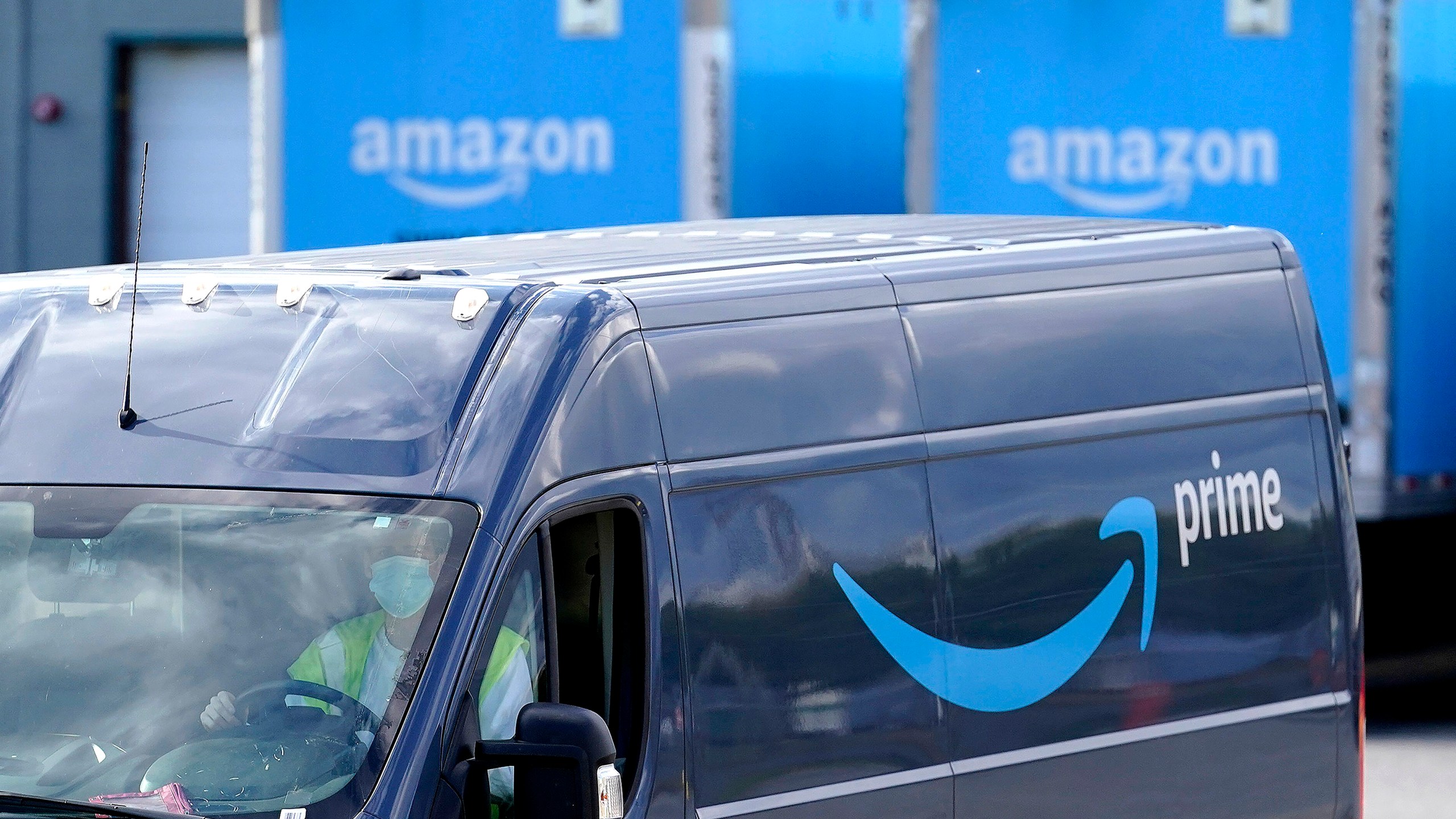 FILE - An Amazon Prime logo appears on the side of a delivery van as it departs an Amazon Warehouse location in Dedham, Mass., Oct. 1, 2020. (AP Photo/Steven Senne, File)