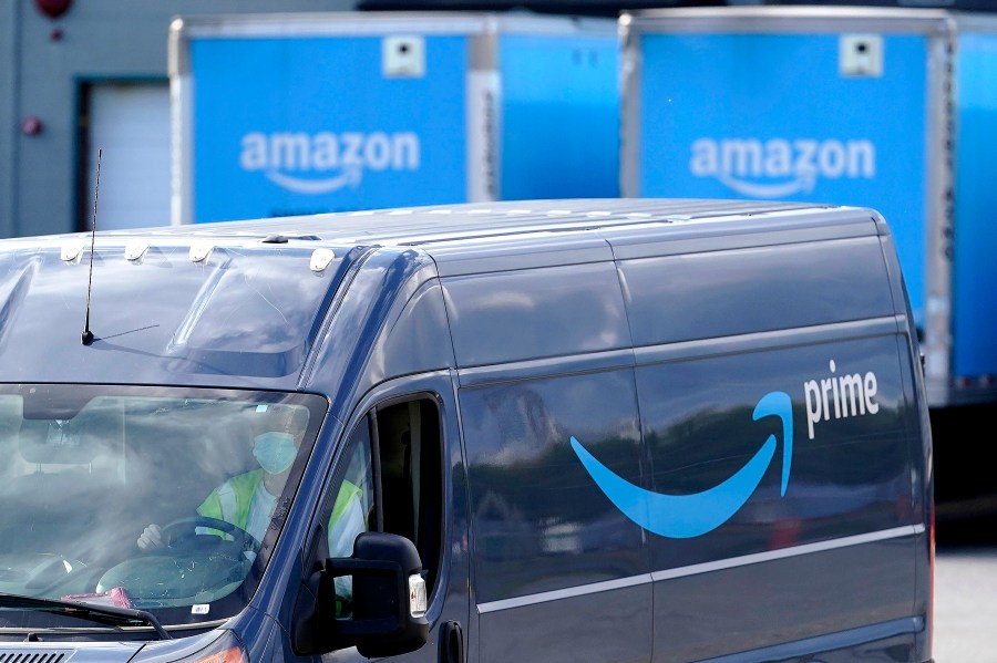 FILE - An Amazon Prime logo appears on the side of a delivery van as it departs an Amazon Warehouse location in Dedham, Mass., Oct. 1, 2020. (AP Photo/Steven Senne, File)