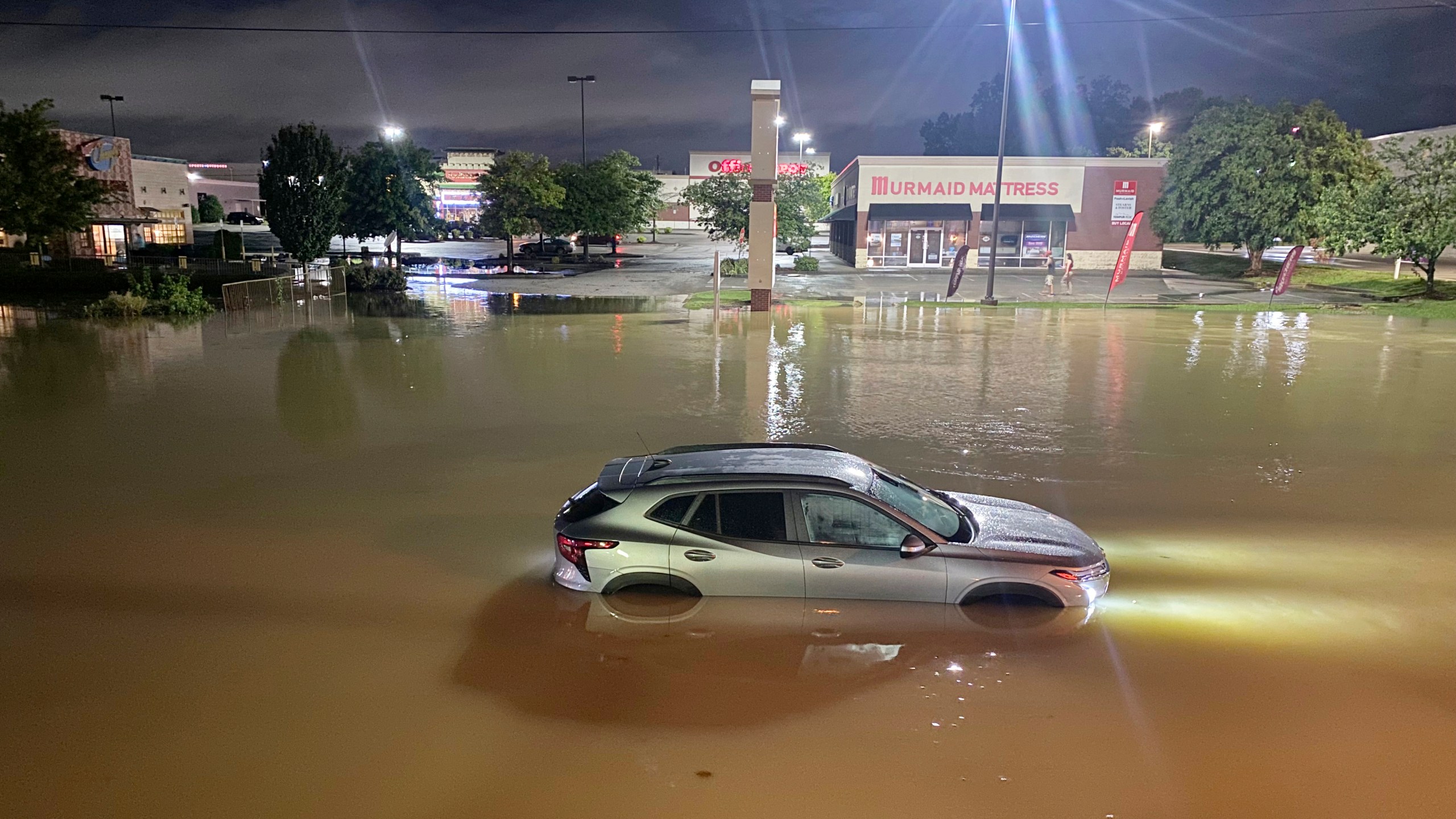 A car is stranded in floodwater on Gunbarrel Road, in Chattanooga, Tenn., on Aug. 12, 2025. (Robin Rudd/Chattanooga Times Free Press via AP)
