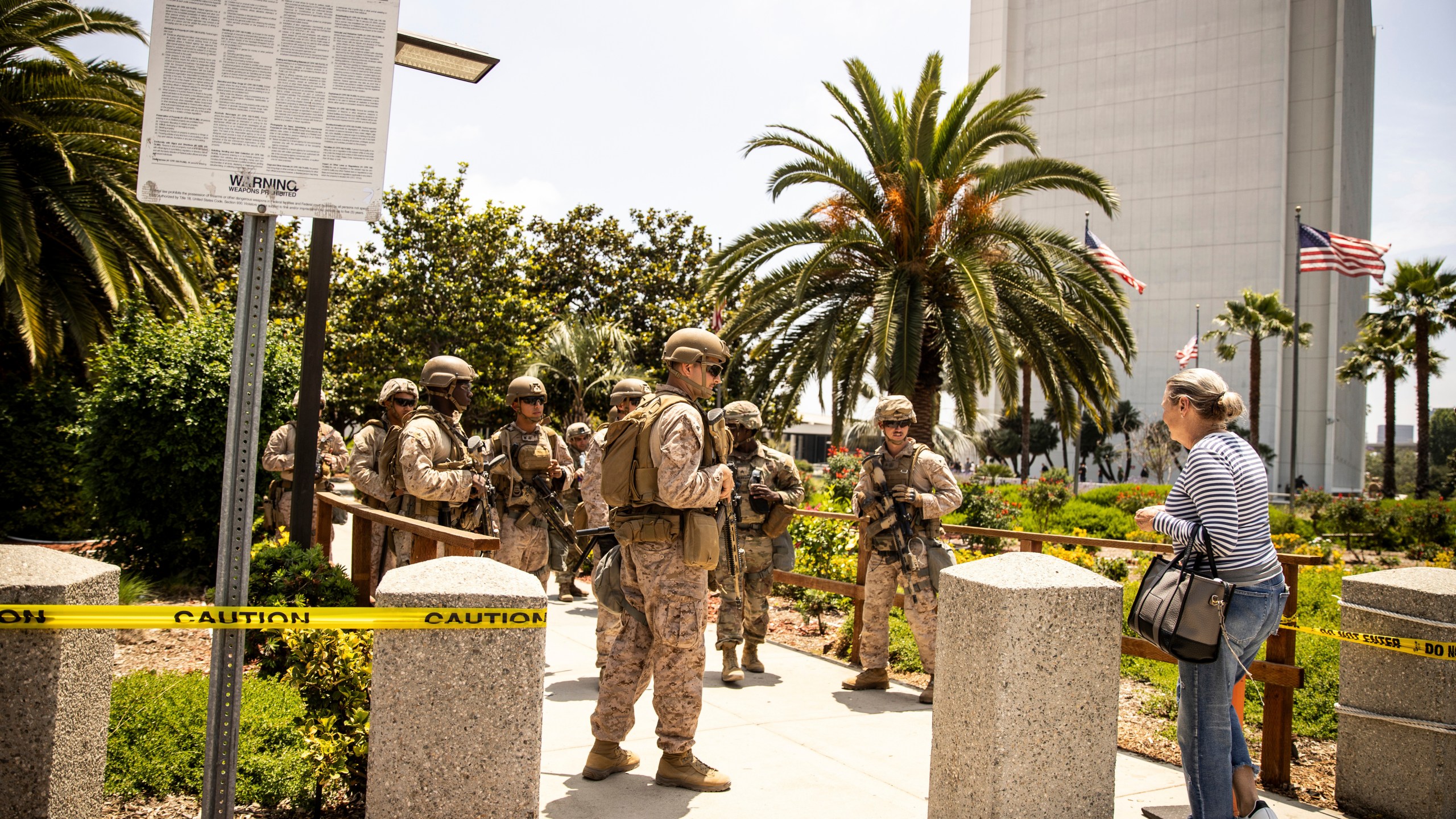 FILE - Members of the California National Guard and U.S. Marines, guard the entrance outside the Wilshire Federal in Los Angeles, June 13, 2025. (Stephen Lam/San Francisco Chronicle via AP, File)