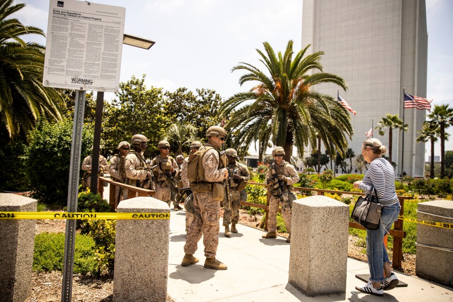 FILE - Members of the California National Guard and U.S. Marines, guard the entrance outside the Wilshire Federal in Los Angeles, June 13, 2025. (Stephen Lam/San Francisco Chronicle via AP, File)