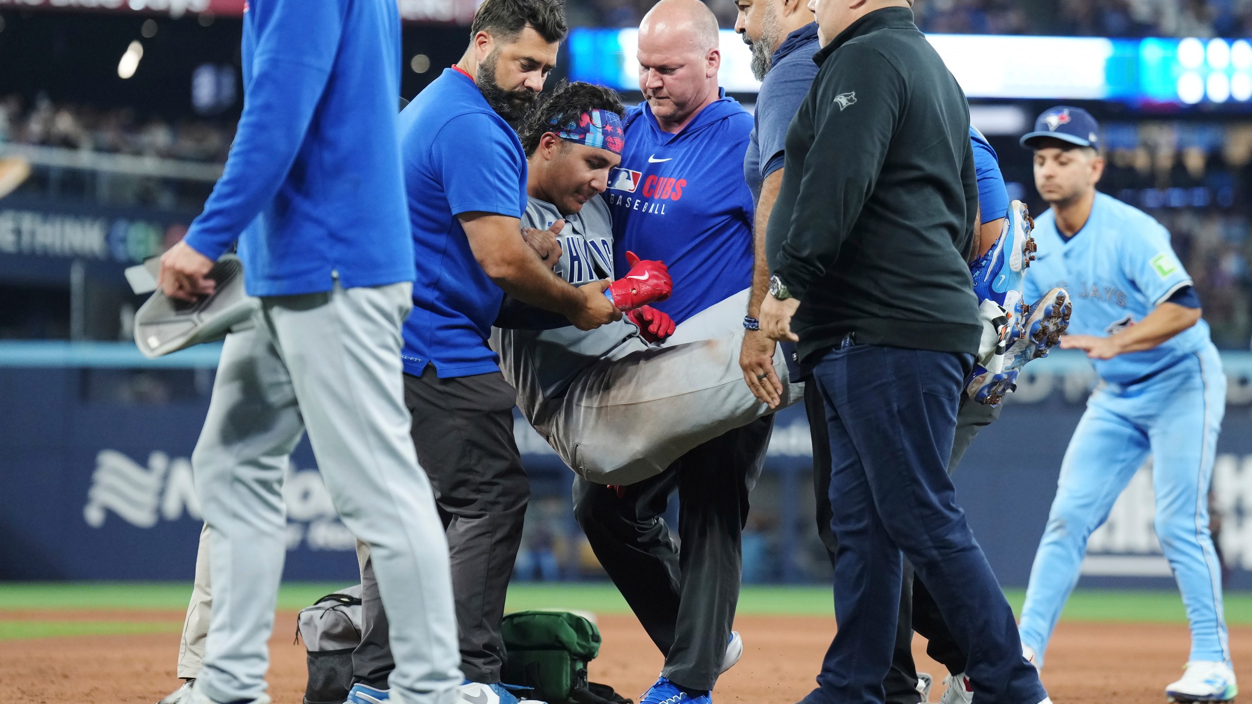 Chicago Cubs catcher Miguel Amaya (9) is tended to by medical staff and leaves the game during eighth inning MLB baseball action against the Toronto Blue Jays in Toronto on Wednesday, August 13, 2025. (Nathan Denette/The Canadian Press via AP)