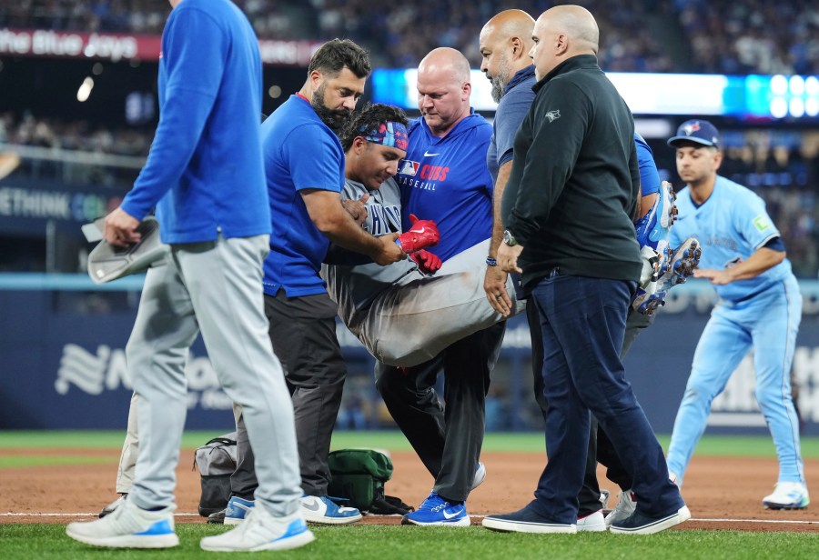 Chicago Cubs catcher Miguel Amaya (9) is tended to by medical staff and leaves the game during eighth inning MLB baseball action against the Toronto Blue Jays in Toronto on Wednesday, August 13, 2025. (Nathan Denette/The Canadian Press via AP)