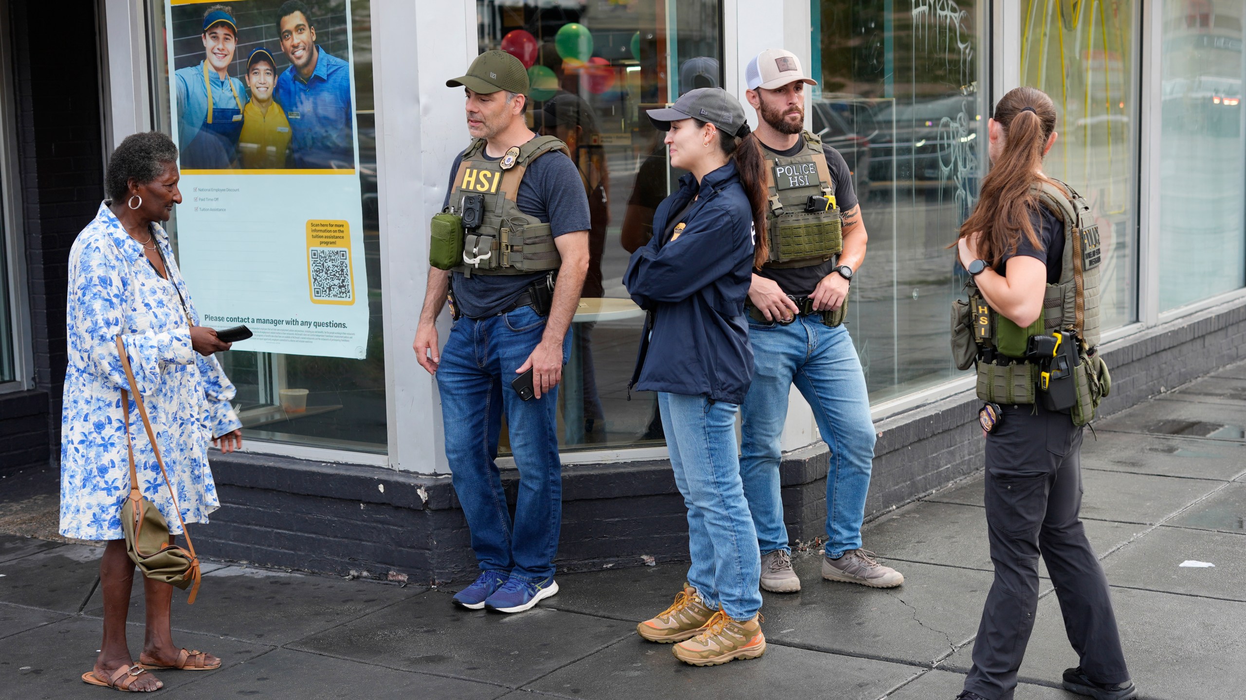 Department of Homeland Security Investigation officers stop to talk to a member of the community at the intersection of 14th and U Streets in northwest Washington, while on patrol Wednesday, Aug. 13, 2025. (AP Photo/Pablo Martinez Monsivais)