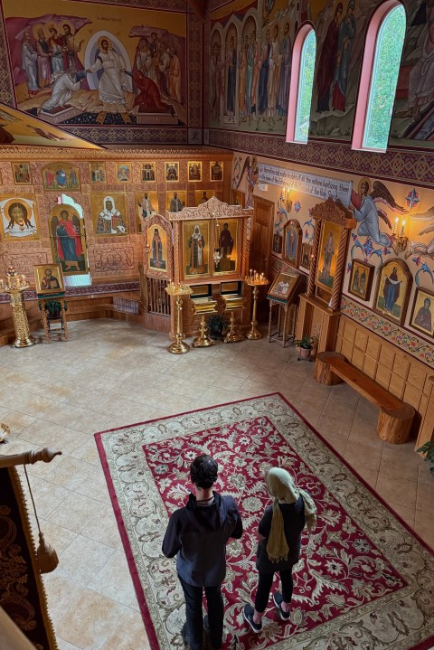 Two parishioners pray at St. Tikhon Orthodox Church in Anchorage during an Akathist service dedicated to peace in Ukraine on Wednesday, Aug. 13, 2025. (AP Photo/ Daniel Kozin)