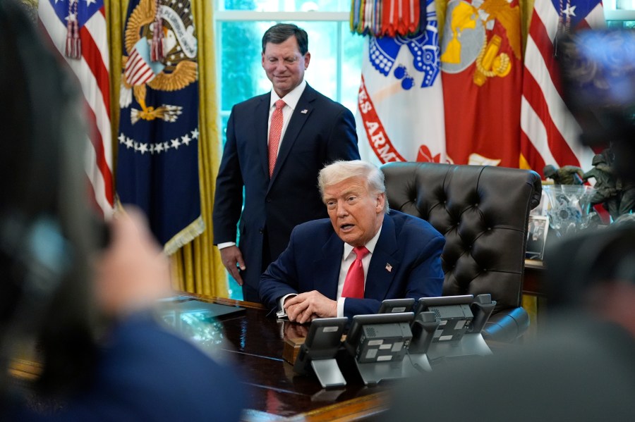 President Donald Trump speaks with reporters as Social Security Commissioner Frank Bisignano listens during an event in the Oval Office to mark the 90th anniversary of the Social Security Act, Thursday, Aug. 14, 2025, in Washington. (AP Photo/Alex Brandon)
