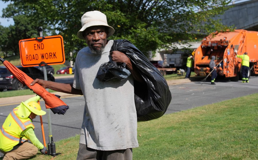 George, 67, walks away with what's left of his belongings, after the city put his mattress and other belongings in a garbage truck, Thursday, Aug. 14, 2025, in Washington. (AP Photo/Jacquelyn Martin)